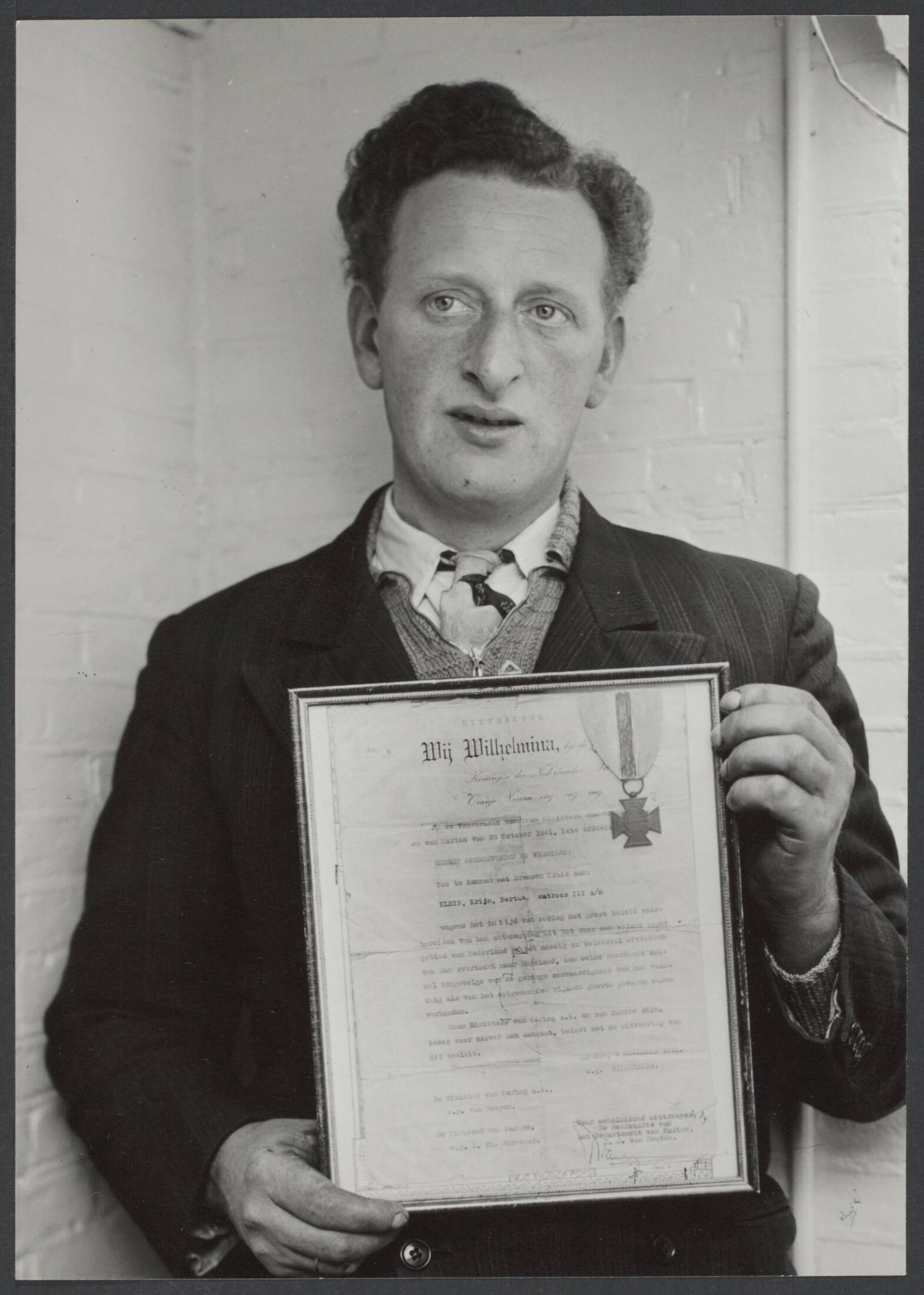 Engelandvaarders / Englandspiel — Scheveningse visser Krijn Kleijn, die in 1941, met nog 6 anderen, in 'n vlot naar Engeland was overgestoken en door koningin Wilhelmina werd ontvangen. Hij toont oorkonde van koningin Wilhelmina, met onderscheiding] — Foto: Stuifbergen, Wilh. L. (Pim) / Spaarnestad (1). Licentie: Set B: Rechtenvrij / Publiek Domein. Bron: Nationaal Archief. http://hdl.handle.net/10648/29c994c1-dd73-c9d2-43af-47ed68ca9cae