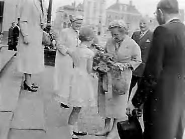 Fotocollectie Anefo — Koningin Juliana bezoekt Deventer en Vriezenveen. Meisje biedt de koningin bloemen aan in Deventer — Foto: Pot, Harry / Anefo. Licentie: Set B: Rechtenvrij / Publiek Domein. Bron: Nationaal Archief. http://hdl.handle.net/10648/a97b87dc-d0b4-102d-bcf8-003048976d84