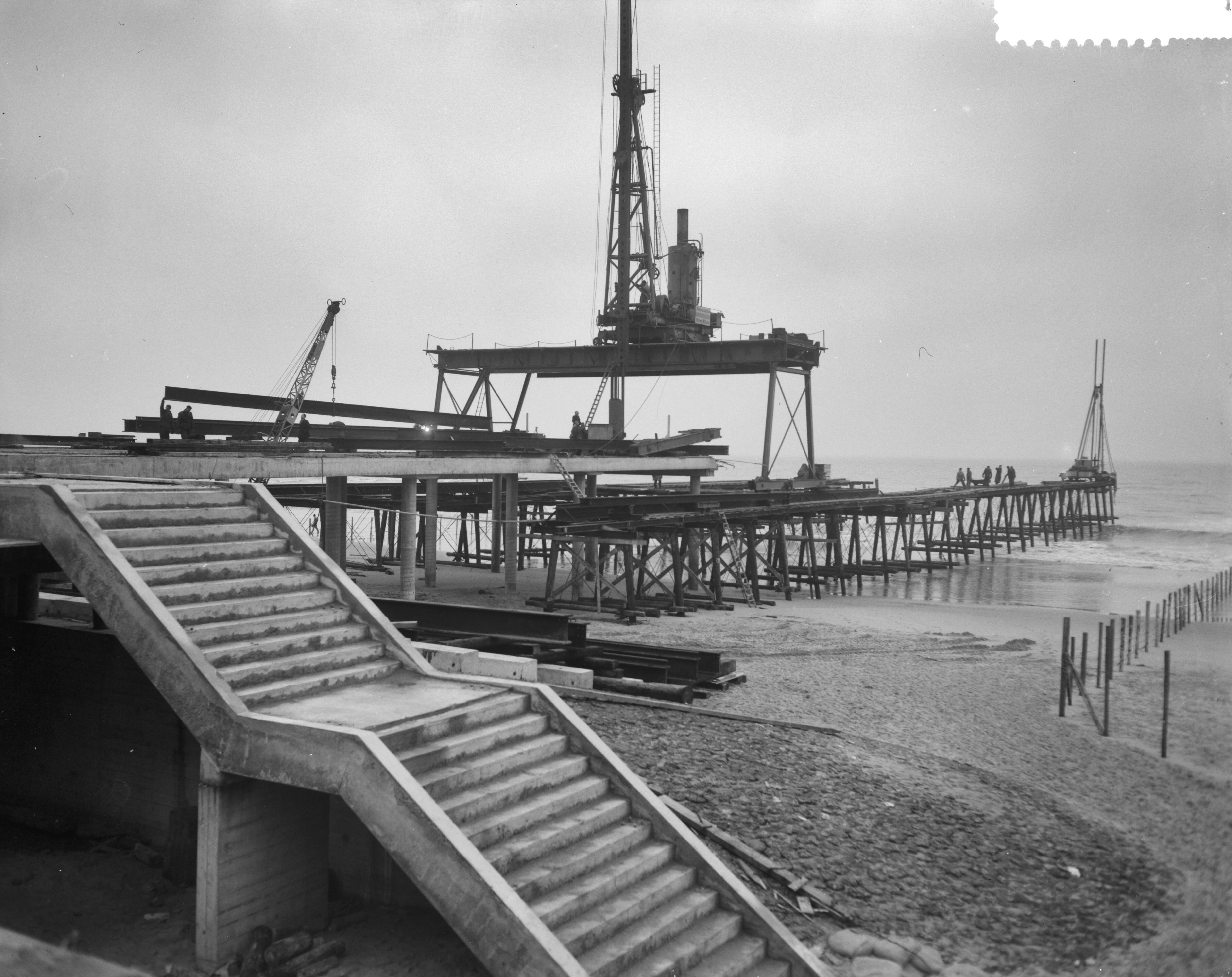 Fotocollectie Anefo — Bouw pier te Scheveningen — Foto: Bilsen, Joop van / Anefo. Licentie: Set B: Rechtenvrij / Publiek Domein. Bron: Nationaal Archief. http://hdl.handle.net/10648/a9a8c3e6-d0b4-102d-bcf8-003048976d84