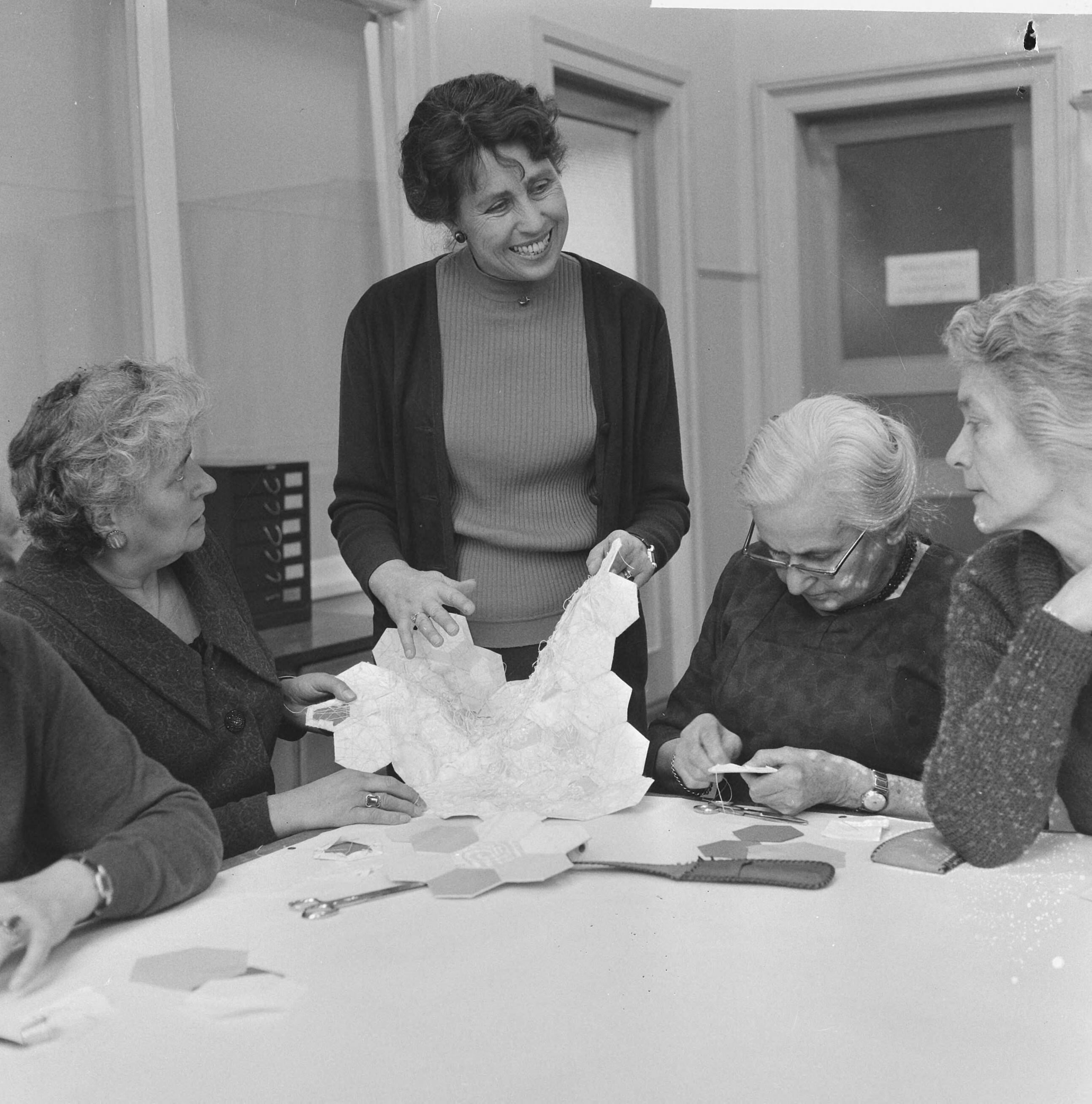 Fotocollectie Anefo — Sprei als huwelijksgeschenk voor prinses Beatrix , mevro Cremers de Bruijn toont de dames een voorbeeld (echtgeno Burgemeester van Haarlem) — Foto: Kroon, Ron / Anefo. Licentie: Set B: Rechtenvrij / Publiek Domein. Bron: Nationaal Archief. http://hdl.handle.net/10648/aad61b38-d0b4-102d-bcf8-003048976d84
