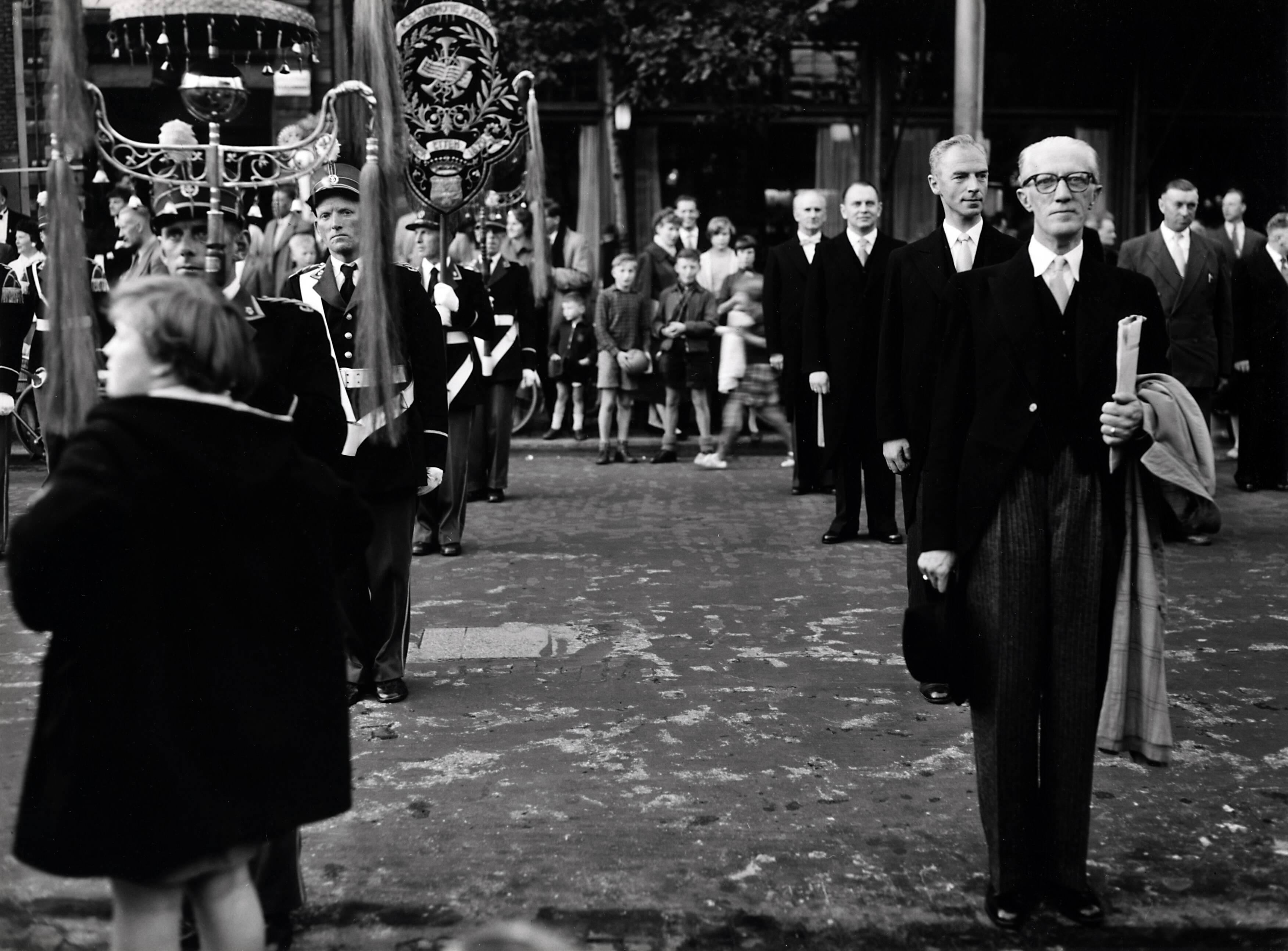 Collectie nader te bepalen — 50-jarig jubileum N.V. De Spaarnestad. [Bijeenkomst bij het standbeeld van Laurens Jansz. Coster in Haarlem] [een rij mannen staat opgesteld, rechts een rij leden van muziekkorpsen of fanfares] — Foto: Fotograaf Onbekend / Fotobureau onbekend / Spaarnestad Photo (05887). Licentie: Set B: Rechtenvrij / Publiek Domein. Bron: Nationaal Archief. http://hdl.handle.net/10648/35429da6-3a72-a382-e063-6df0900a6686