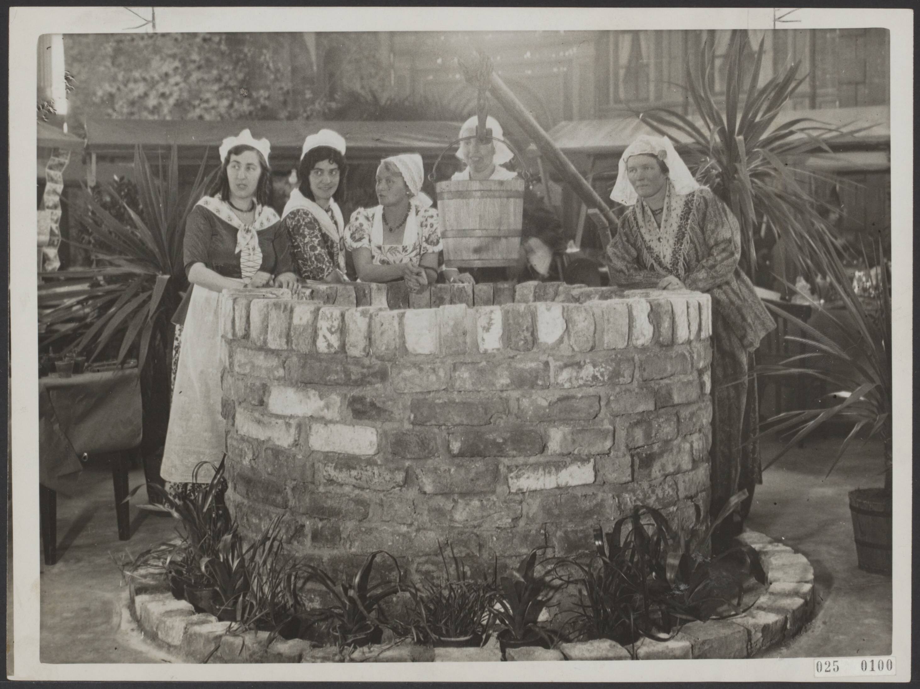 Fotocollectie Elsevier Binnenland — Opening tentoonstelling "Oud-Leeuwarden" in het Beursgebouw te Leeuwarden. Vrouwen in klederdracht rond een put — Foto: N.V. Polygoon. Licentie: Set B: Rechtenvrij / Publiek Domein. Bron: Nationaal Archief. http://hdl.handle.net/10648/add98bda-d0b4-102d-bcf8-003048976d84