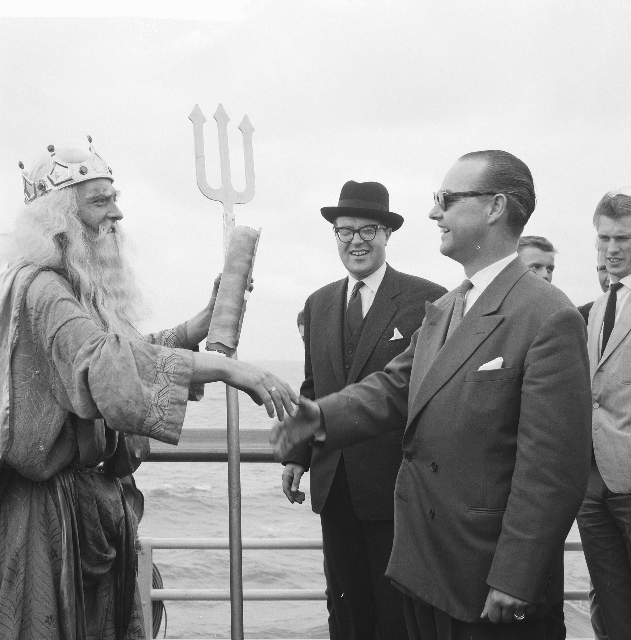 Fotocollectie Anefo — Miljoenste bezoeker op Scheveningse Pier. Neptunus en en de 39-jarige Rotterdamse zakenman R. Driebeek — Foto: Lindeboom, Henk / Anefo. Licentie: Set B: Rechtenvrij / Publiek Domein. Bron: Nationaal Archief. http://hdl.handle.net/10648/a9dd29ec-d0b4-102d-bcf8-003048976d84