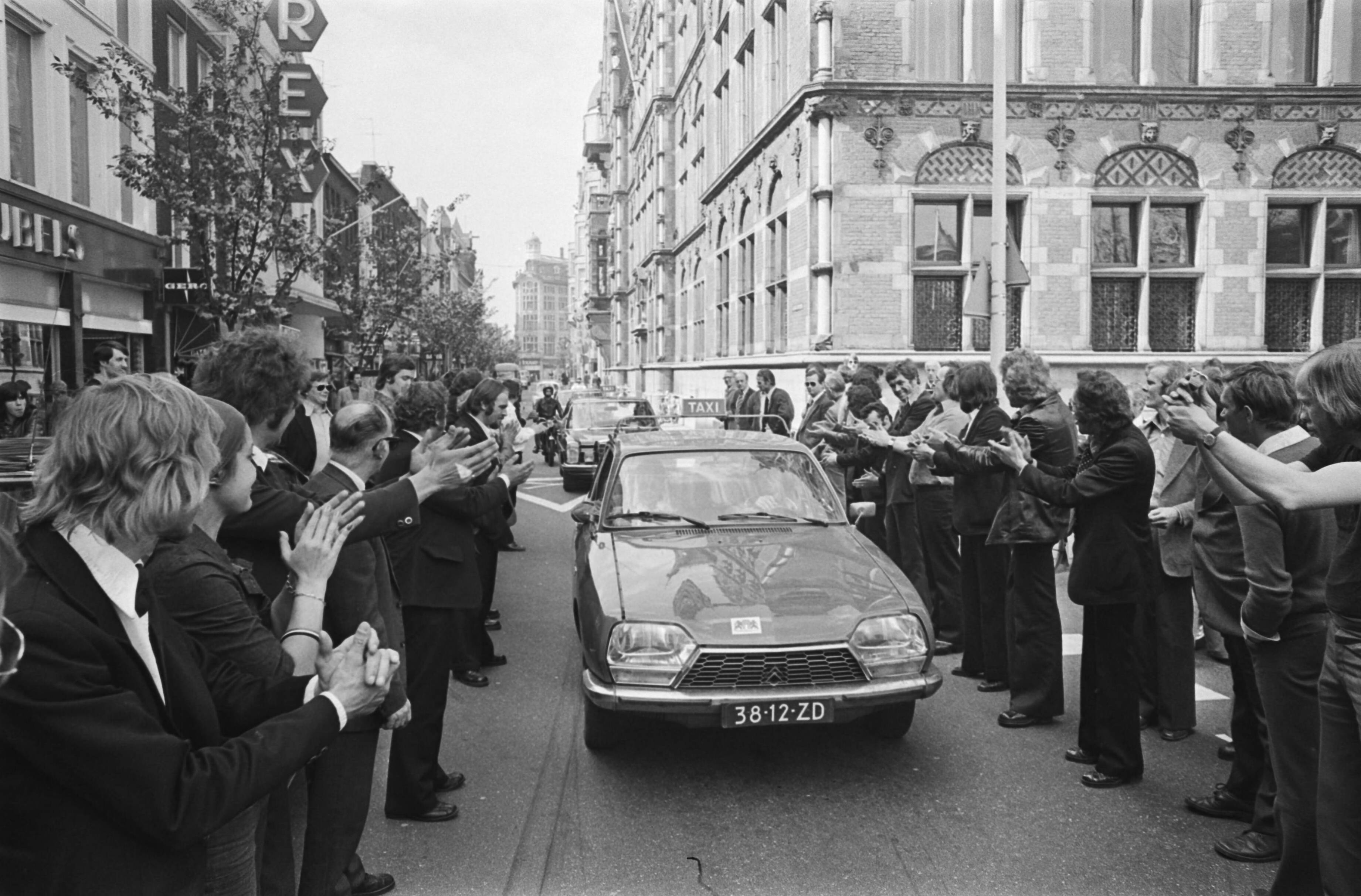 Fotocollectie Anefo — Taxiblokkades in Den Haag ; na afloop blokkades verzameld op Haagse Plein; reeds gearriveerde chauffeurs begroeten aankomende collega's met applaus — Foto: Verhoeff, Bert / Anefo. Licentie: Set B: Rechtenvrij / Publiek Domein. Bron: Nationaal Archief. http://hdl.handle.net/10648/ac82f280-d0b4-102d-bcf8-003048976d84