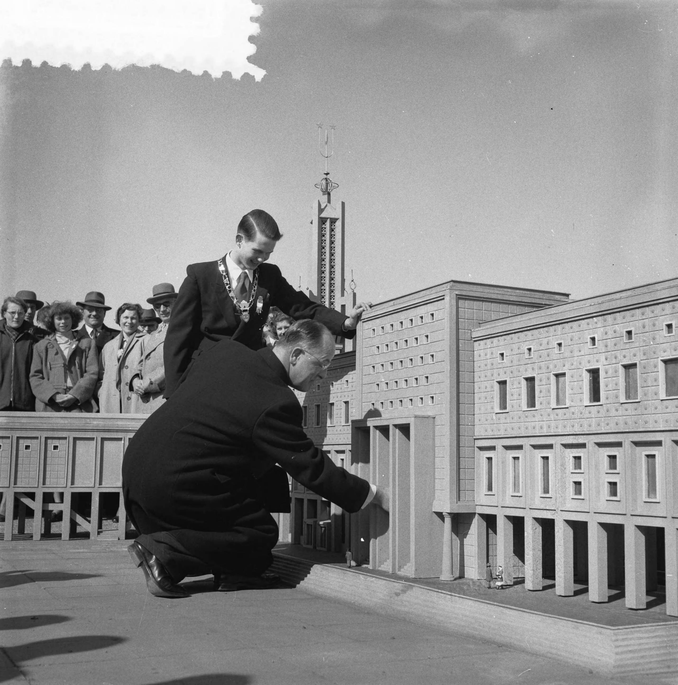 Fotocollectie Anefo — Opening Madurodam. Burgemeester F.M.A. Schokking van Den Haag knielt om met een sleuteltje het raadhuis van Madurodam. Jeugdburgemeester van Madurodam Rolf Simon van Leeuwen kijk belangstellend toe — Foto: Noske, J.D. / Anefo. Licentie: Set B: Rechtenvrij / Publiek Domein. Bron: Nationaal Archief. http://hdl.handle.net/10648/a91f7c80-d0b4-102d-bcf8-003048976d84