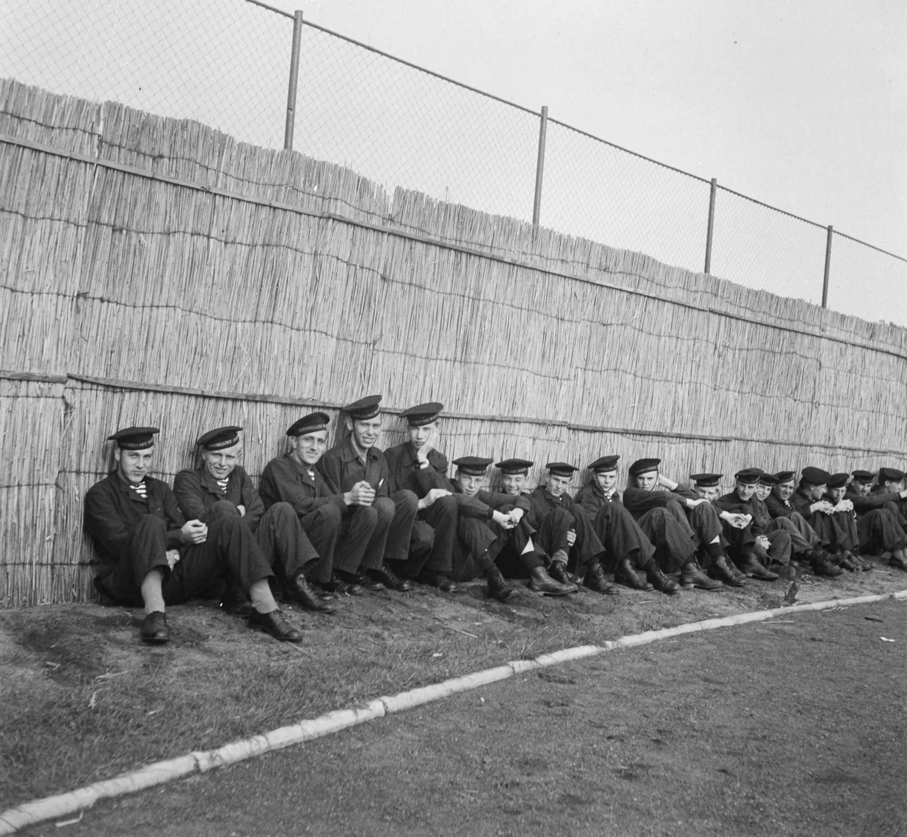 MOK Hilversum 1948 — MOK Hilversum. Matrozen tegen rieten achtergrond — Foto: Steenkamp, B.J.J. (Ben) / Anefo. Licentie: Set B: Rechtenvrij / Publiek Domein. Bron: Nationaal Archief. http://hdl.handle.net/10648/a8bd99ca-d0b4-102d-bcf8-003048976d84