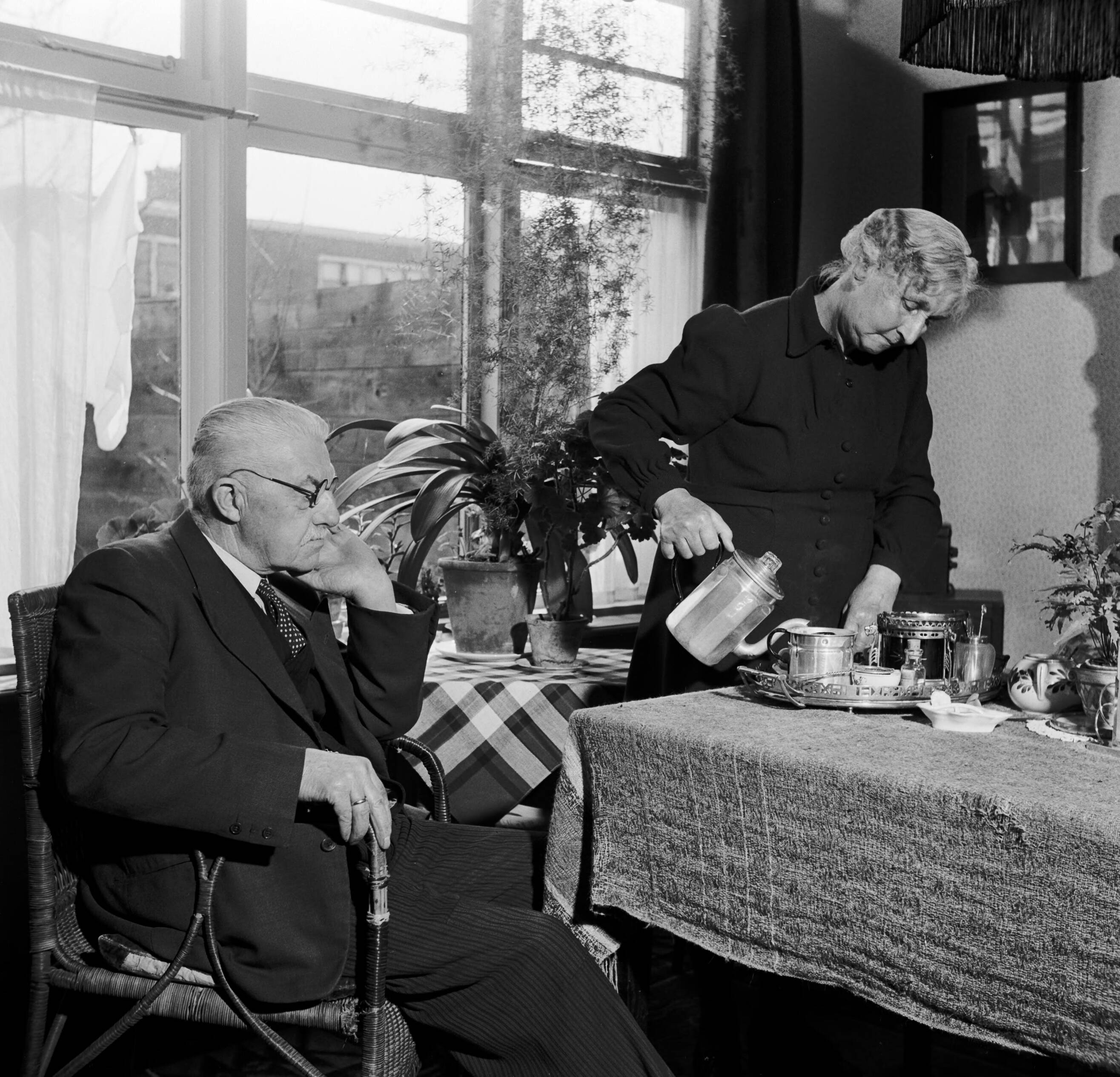 Fotocollectie Van de Poll — Het echtpaar S. de Jong in hun woonkamer in het Friese Huizum (nu deel van Leeuwarden) — Foto: Poll, Willem van de. Licentie: Set B: Rechtenvrij / Publiek Domein. Bron: Nationaal Archief. http://hdl.handle.net/10648/aeccc14c-d0b4-102d-bcf8-003048976d84
