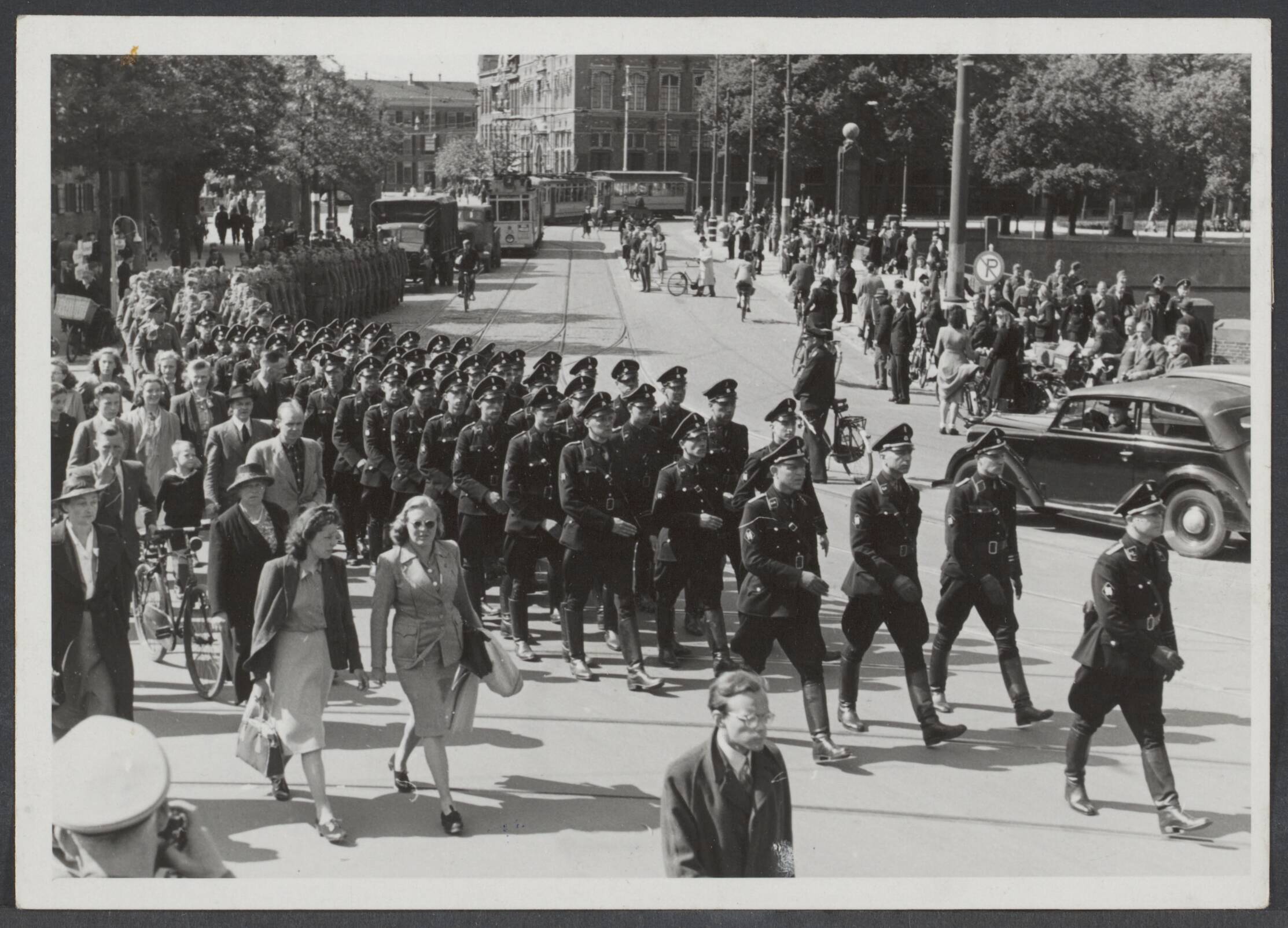 Nederlandse S.S. (Waffen SS.) — Vertrek van honderden vrijwilligers van de Nederlandse SS naar het Oostfront waar ze worden opgenomen in de Waffen-SS. Tijdens hun mars door Den Haag naar het station. Geheel vooraan commandant Feldmeijer — Foto: Stapf Bilderdienst. Licentie: Set B: Rechtenvrij / Publiek Domein. Bron: Nationaal Archief. http://hdl.handle.net/10648/e06d832e-4088-f732-4598-119302090fcd