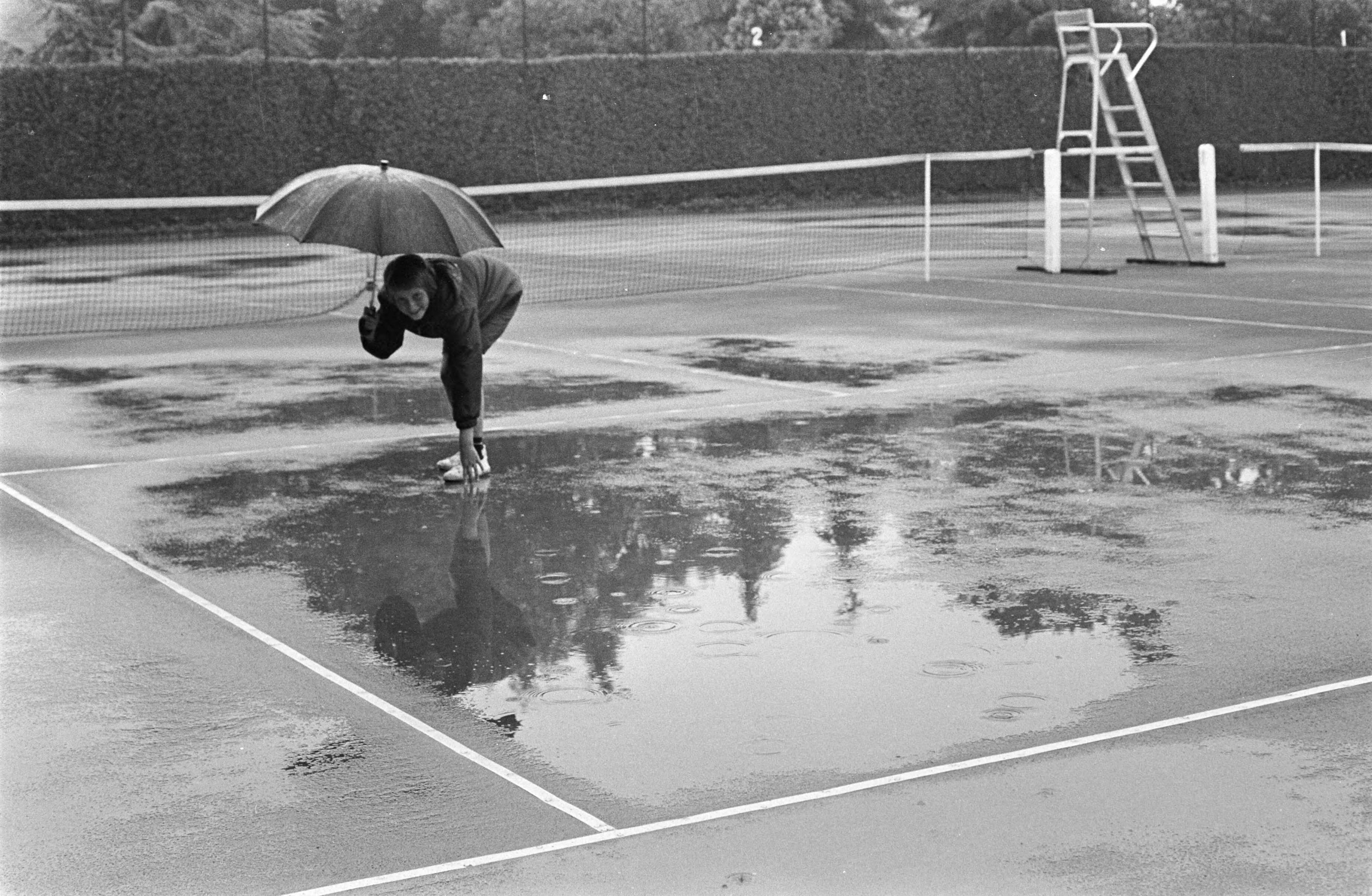 Fotocollectie Anefo — Internationale Tenniswedstrijden te Hilversum afgelast. De baan vol met water — Foto: Kroon, Ron / Anefo. Licentie: Set B: Rechtenvrij / Publiek Domein. Bron: Nationaal Archief. http://hdl.handle.net/10648/ab4791f0-d0b4-102d-bcf8-003048976d84