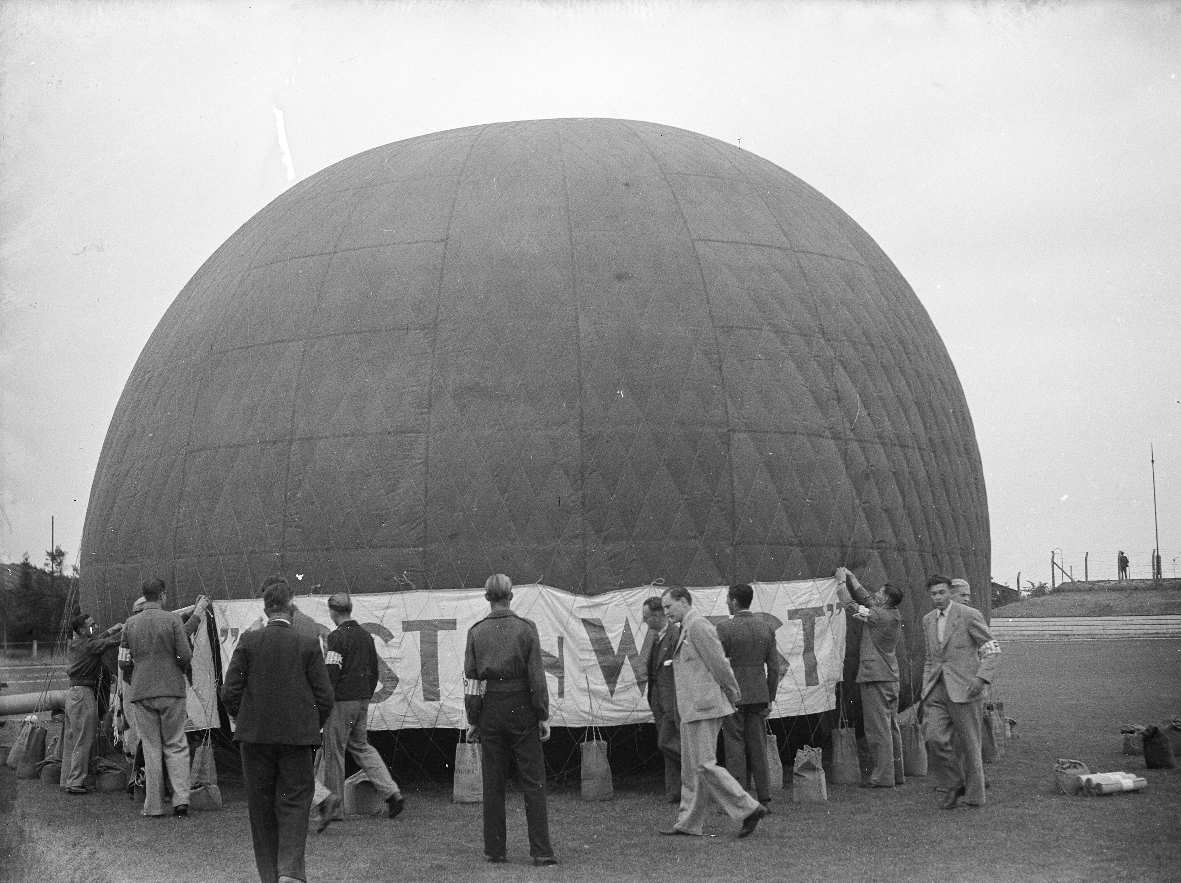 Fotocollectie Anefo — Landdag van de koninklijke vereniging "Oost en West" op het Hilversumse Sportpark. Tegen het einde van de landd&g steeg commandant Boesman met de ballon „Rambaldo" op. Er was zeer weinig wind, zodat hij bij Werkhoven nabij Utrecht enkele uren later ciaalde. — Foto: Sagers, Harry / Anefo. Licentie: Set B: Rechtenvrij / Publiek Domein. Bron: Nationaal Archief. http://hdl.handle.net/10648/a8adc342-d0b4-102d-bcf8-003048976d84
