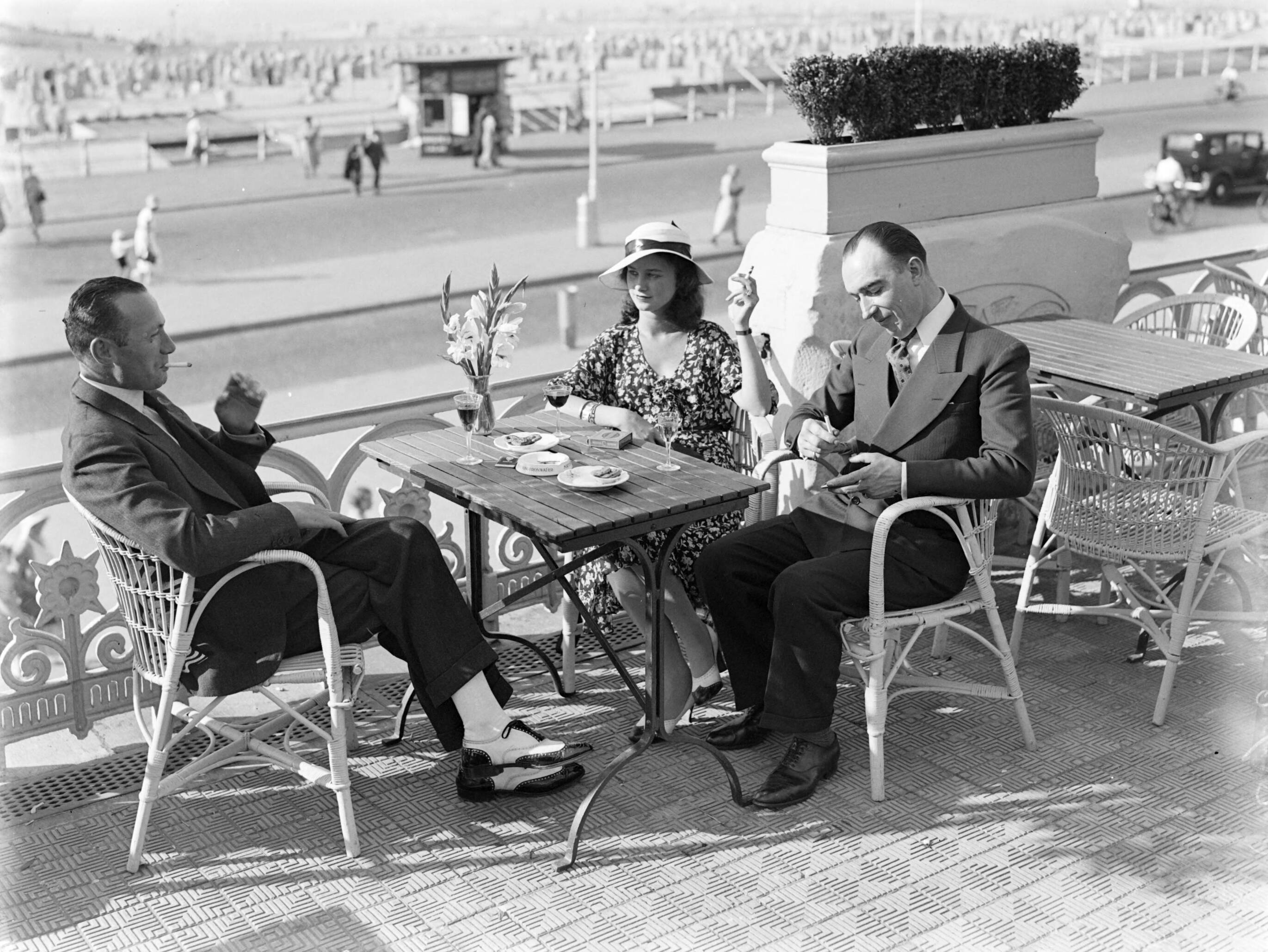 Scheveningen. — Een vrouw (mevrouw Ott?) en twee mannen op een terras aan de boulevard in Scheveningen — Foto: Poll, Willem van de. Licentie: Set B: Rechtenvrij / Publiek Domein. Bron: Nationaal Archief. http://hdl.handle.net/10648/ae9ab2ec-d0b4-102d-bcf8-003048976d84