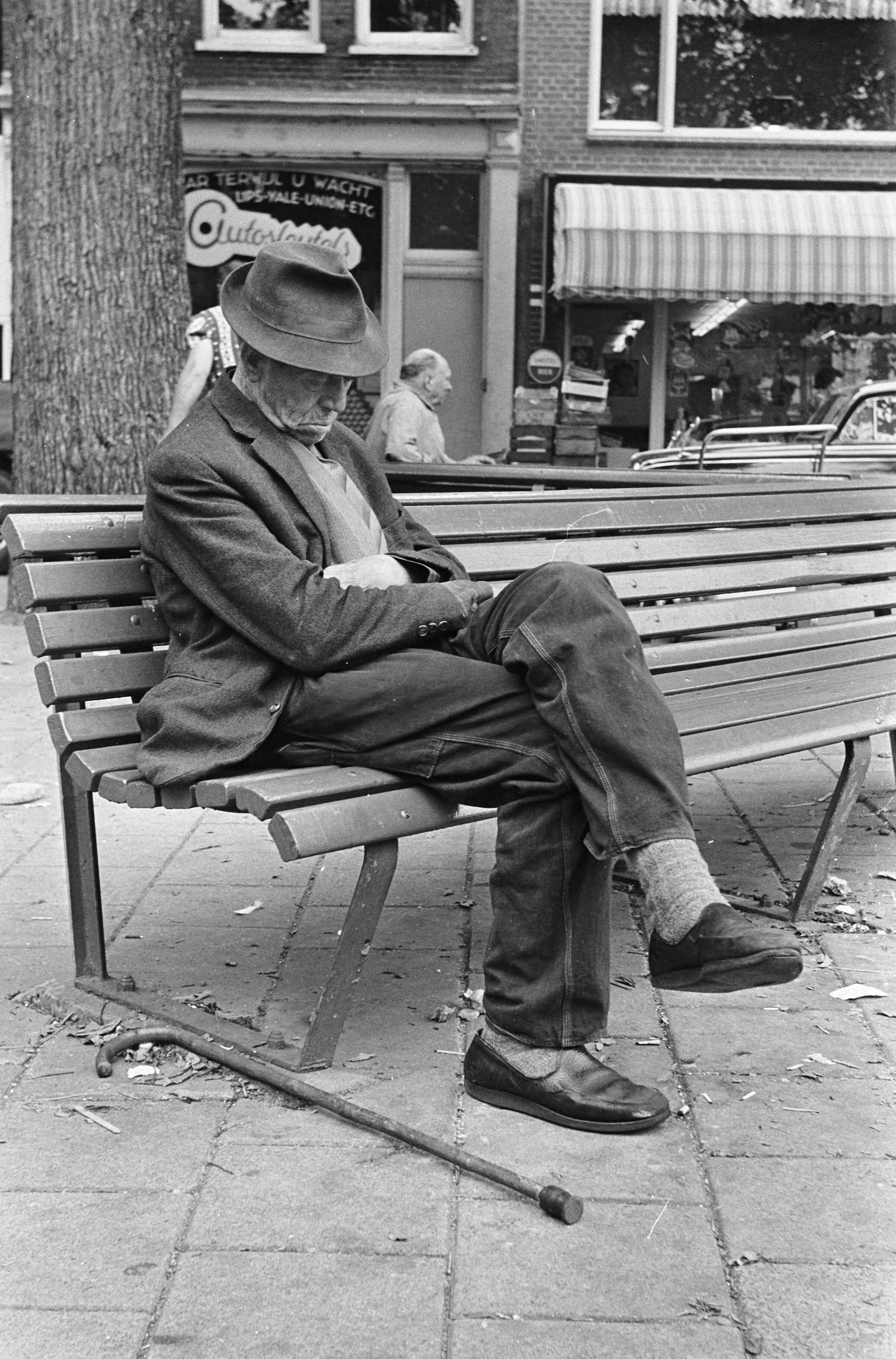 Fotocollectie Anefo — Zomer in de Jordaan (Amsterdam), oud mannetje zit te dutten op een bankje — Foto: Evers, Joost / Anefo. Licentie: Set B: Rechtenvrij / Publiek Domein. Bron: Nationaal Archief. http://hdl.handle.net/10648/aabbabd6-d0b4-102d-bcf8-003048976d84