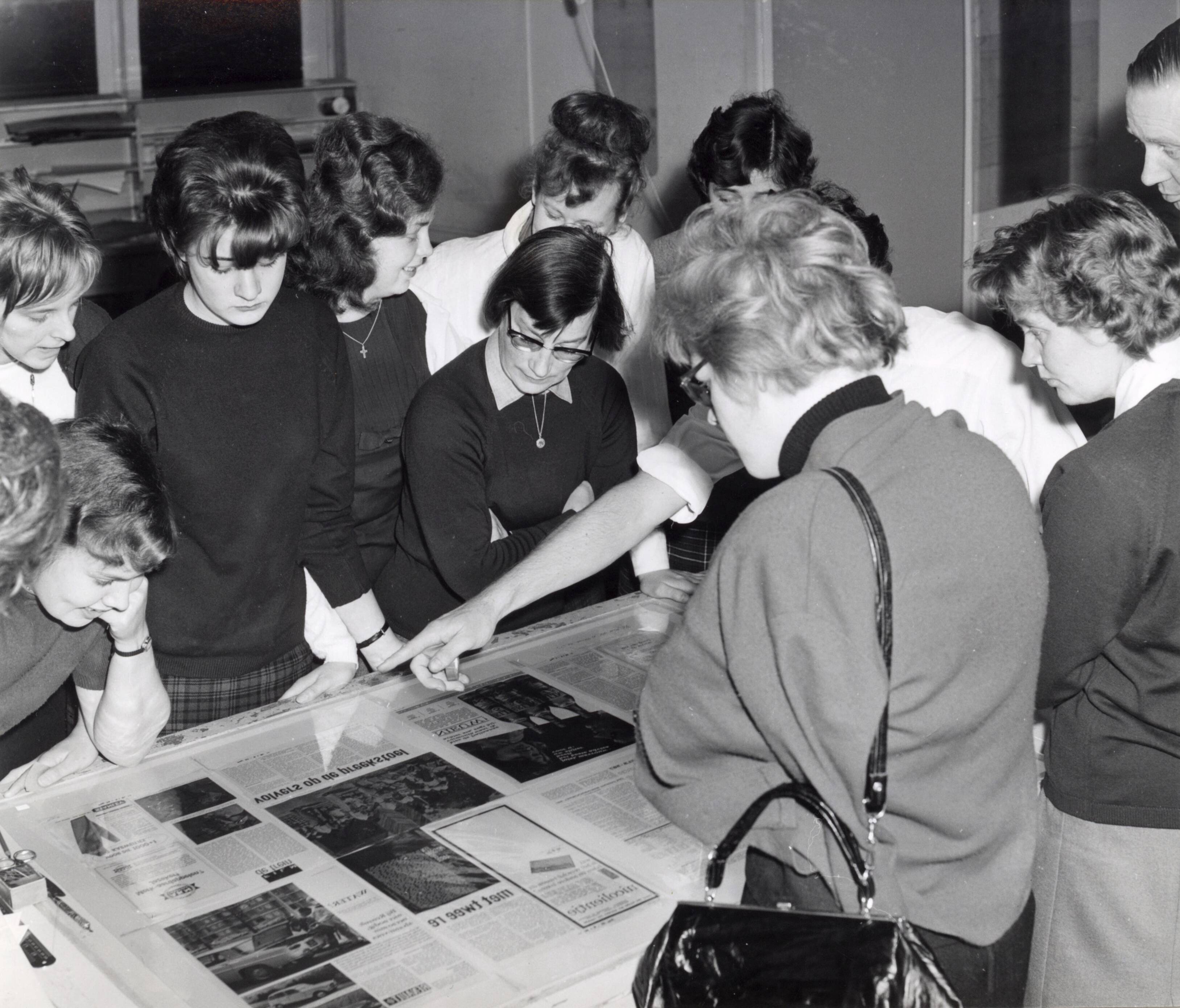 Collectie nader te bepalen — [Serie: Spaarnestad bedrijfsvoering] [jongen vrouwen bekijken tentoongestelde pagina's van kranten en tijdschriften] — Foto: Fotograaf Onbekend / Fotobureau onbekend / Spaarnestad Photo (05887). Licentie: Set B: Rechtenvrij / Publiek Domein. Bron: Nationaal Archief. http://hdl.handle.net/10648/35429da6-414d-a382-e063-6df0900a6686