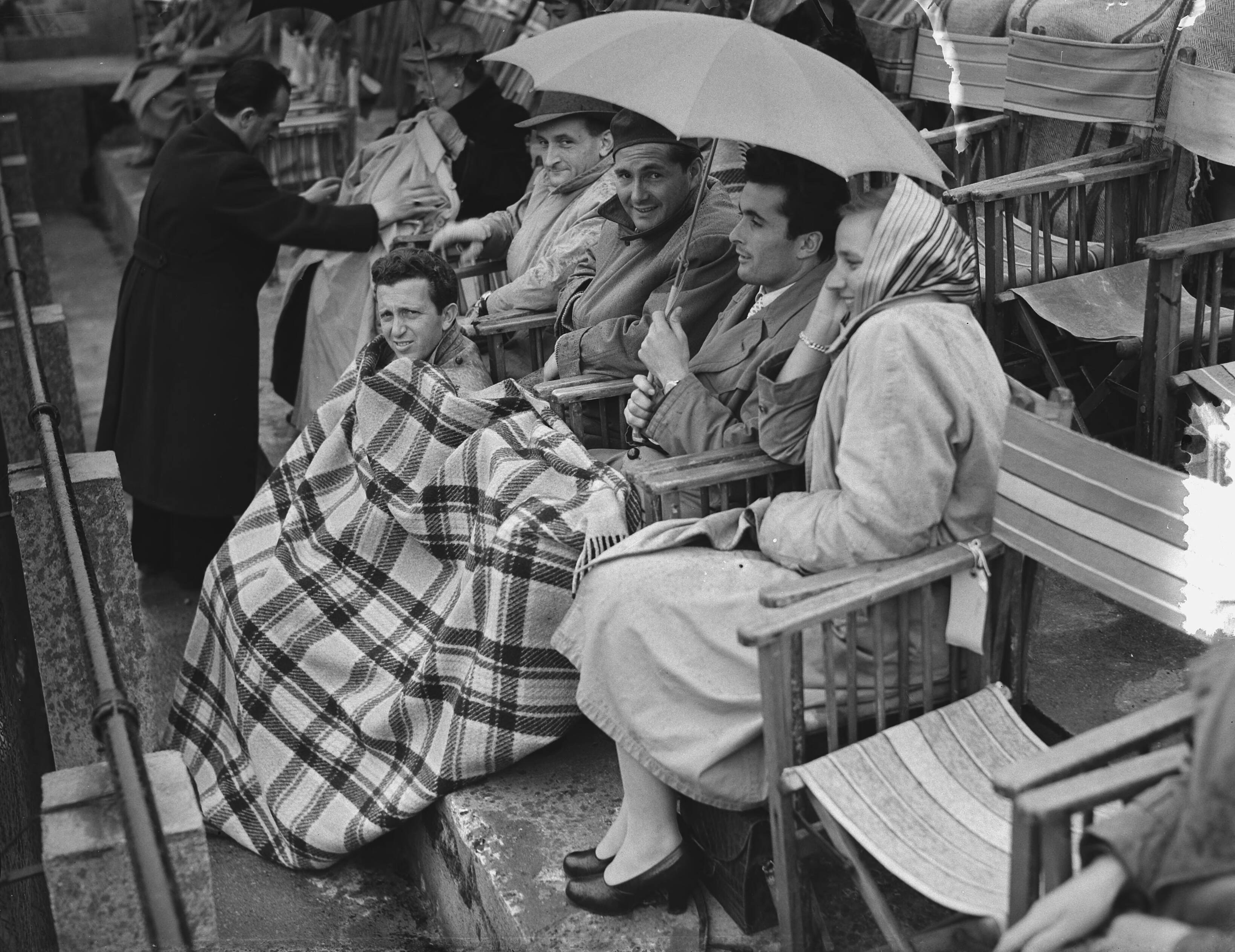 Fotocollectie Anefo — Tennis. Daviscup. Nederland tegen Italië op de METS-banen te Scheveningen. Groepje Italiaanse toeschouwers met paraplu — Foto: Duinen, H. van / Anefo. Licentie: Set B: Rechtenvrij / Publiek Domein. Bron: Nationaal Archief. http://hdl.handle.net/10648/a90c14e2-d0b4-102d-bcf8-003048976d84