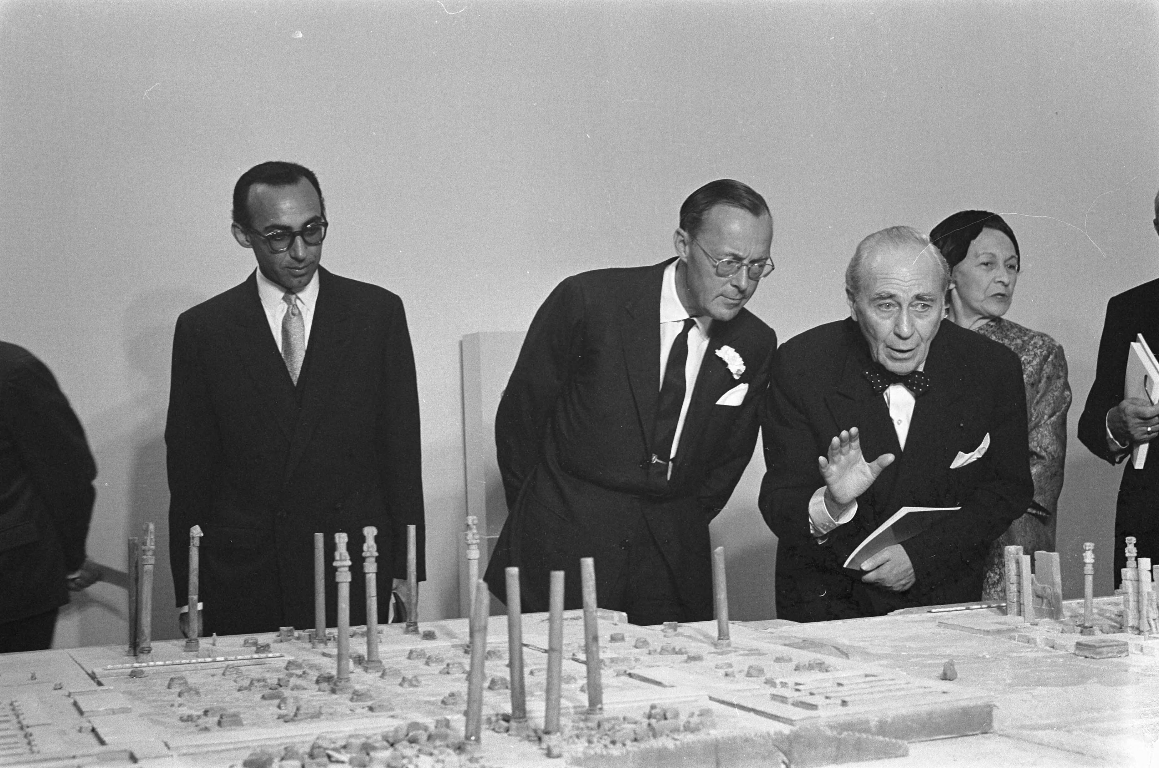 Fotocollectie Anefo — Prins Bernhard opende tentoonstelling 7000 jaar Perzische kunst in het Haagse gemeentemuseum. De prins werd rondgeleid door de directeur van de Franse archeologische dienst in Perzië, prof. Roman Ghirsman. Het gezelschap bij de maquette van Persepolis, vervaardigd door mevr. Ghirsman (rechts). Links de Perzische ambassadeur dr. Ferydoun Adamyat — Foto: Pot, Harry / Anefo. Licentie: Set B: Rechtenvrij / Publiek Domein. Bron: Nationaal Archief. http://hdl.handle.net/10648/aa160c4e-d0b4-102d-bcf8-003048976d84