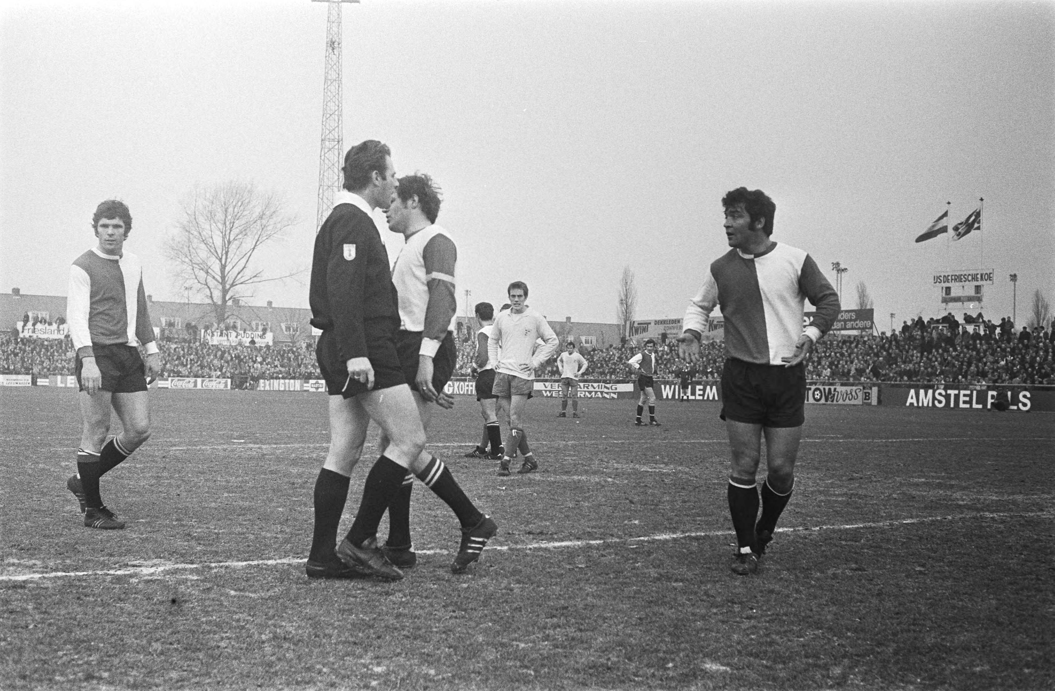 Voetbalwedstrijd voor de KNVB beker Cambuur Leeuwarden - Feyenoord: 0-3 — Woordenwisseling tussen een Feyenoordspeler en de scheidsrechter — Foto: Fotograaf Onbekend / Anefo. Licentie: Set B: Rechtenvrij / Publiek Domein. Bron: Nationaal Archief. http://hdl.handle.net/10648/abb73730-d0b4-102d-bcf8-003048976d84