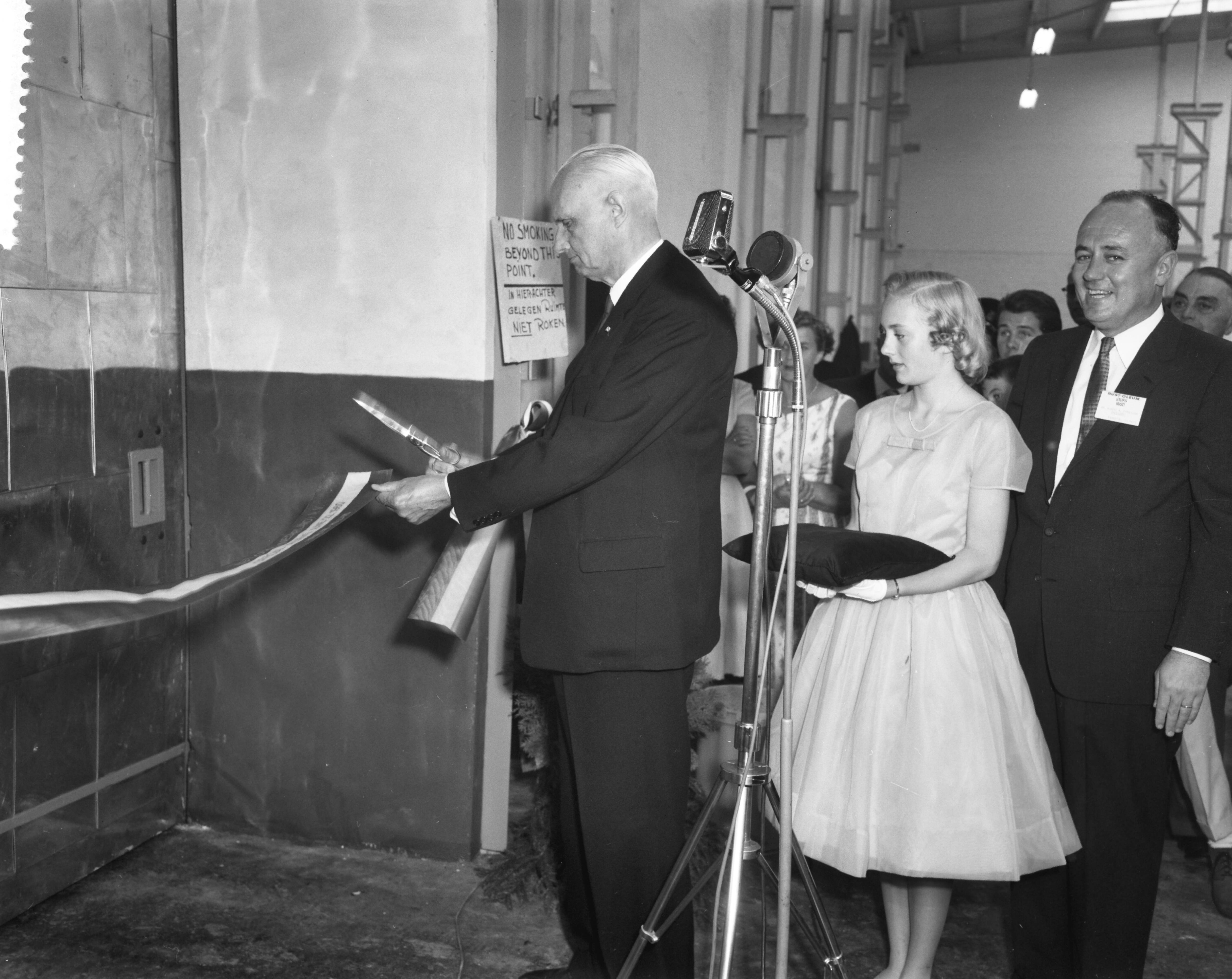 Fotocollectie Anefo — Opening fabriek Rust-Oleum te Haarlem. De Haarlemse wethouder J.A. Schippers knipt lint door. Achter hem Susan Fergusson, kleindochter, en president-directeur Robert Fergusson jr., zoon van de oprichter — Foto: Behrens, Herbert F. / Anefo. Licentie: Set B: Rechtenvrij / Publiek Domein. Bron: Nationaal Archief. http://hdl.handle.net/10648/a9b225f8-d0b4-102d-bcf8-003048976d84