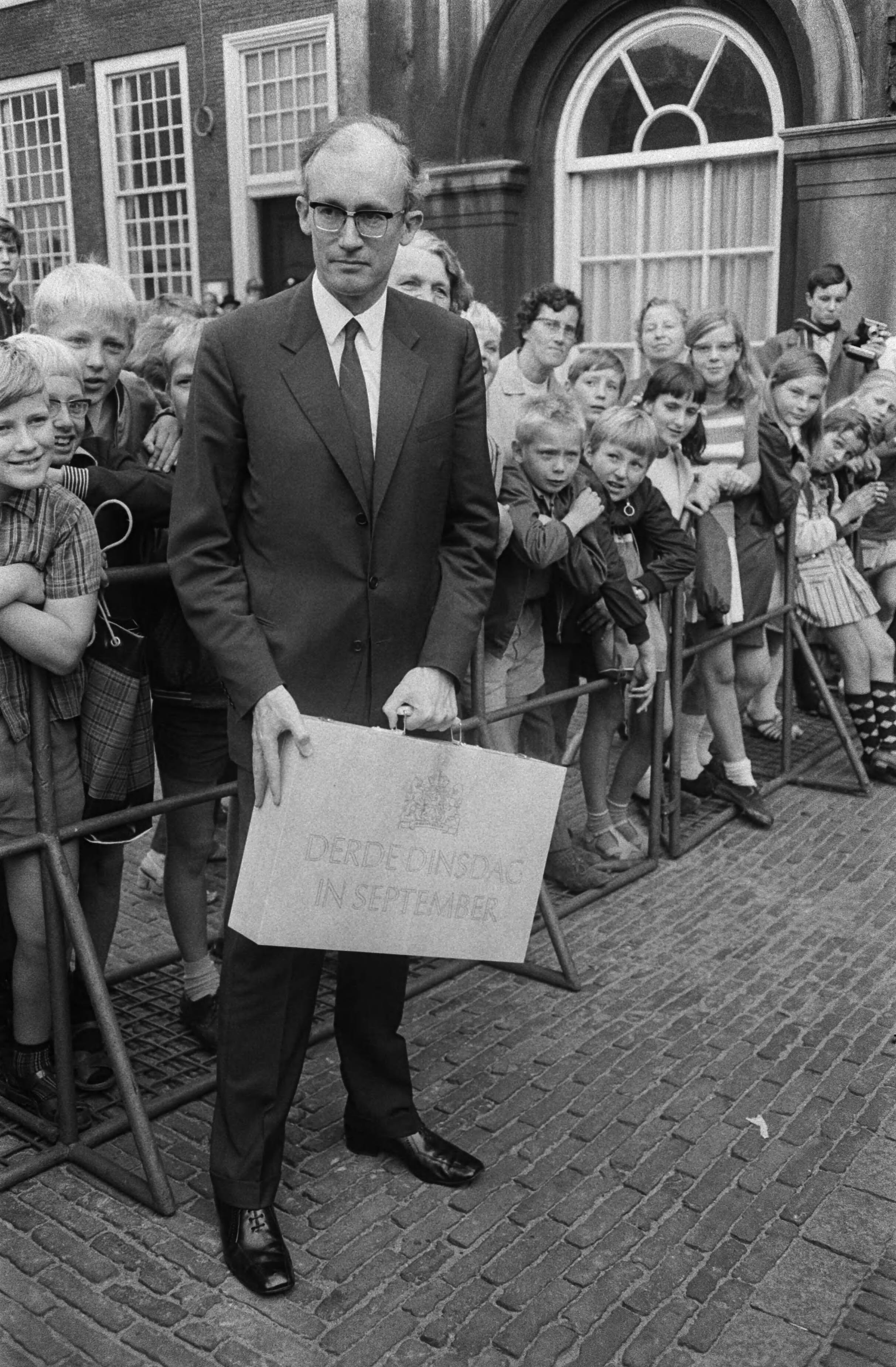 Fotocollectie Anefo — Opening Staten Generaal, Den Haag : Minister Witteveen met het Miljoenenkoffertje bij aankomst Tweede Kamer — Foto: Koch, Eric / Anefo. Licentie: Set B: Rechtenvrij / Publiek Domein. Bron: Nationaal Archief. http://hdl.handle.net/10648/ab79f4ec-d0b4-102d-bcf8-003048976d84