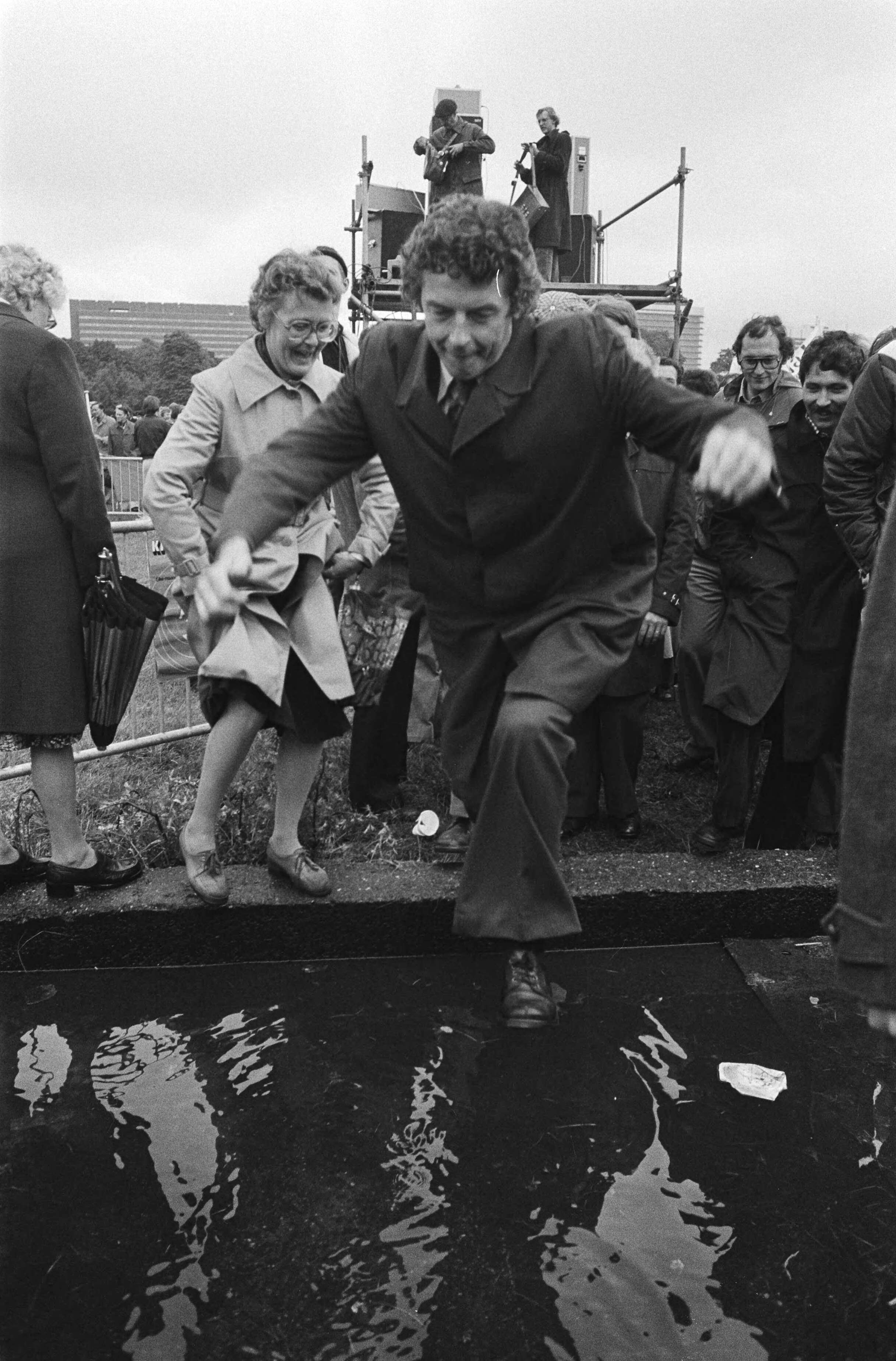 Fotocollectie Anefo — Ambtenarendemonstratie, Den Haag tegen bezuigingsplannen Van Agt ; Wim Kok springt over plas — Foto: Peters, Hans / Anefo. Licentie: Set B: Rechtenvrij / Publiek Domein. Bron: Nationaal Archief. http://hdl.handle.net/10648/acb7760e-d0b4-102d-bcf8-003048976d84