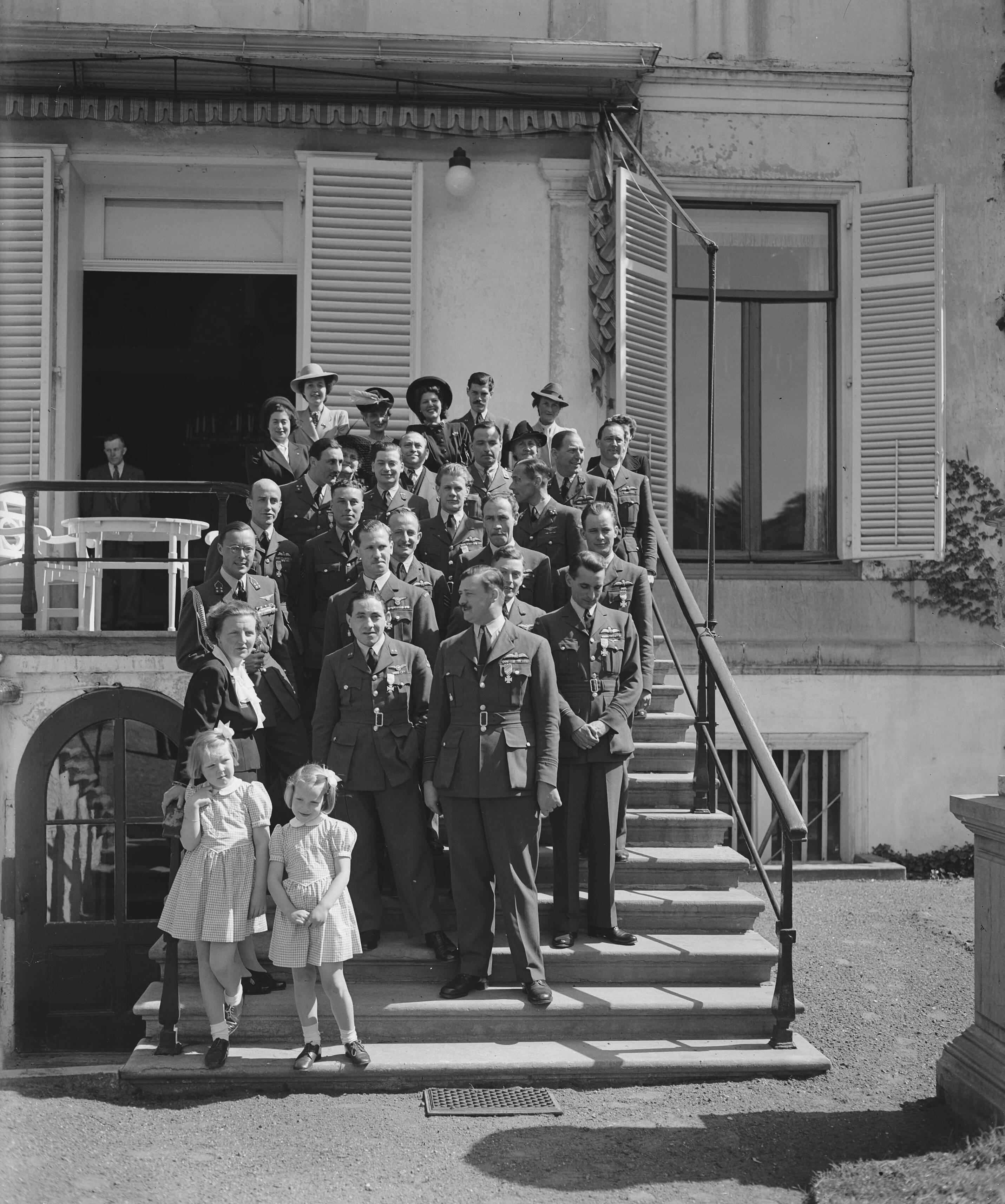 Fotocollectie Anefo — Verjaardag van Prinses Juliana. Groepsfoto van personeel van paleis Soestdijk met de prinsessen Irene en Beatrix — Foto: Raucamp, Koos / Anefo. Licentie: Set B: Rechtenvrij / Publiek Domein. Bron: Nationaal Archief. http://hdl.handle.net/10648/a89d1bf0-d0b4-102d-bcf8-003048976d84
