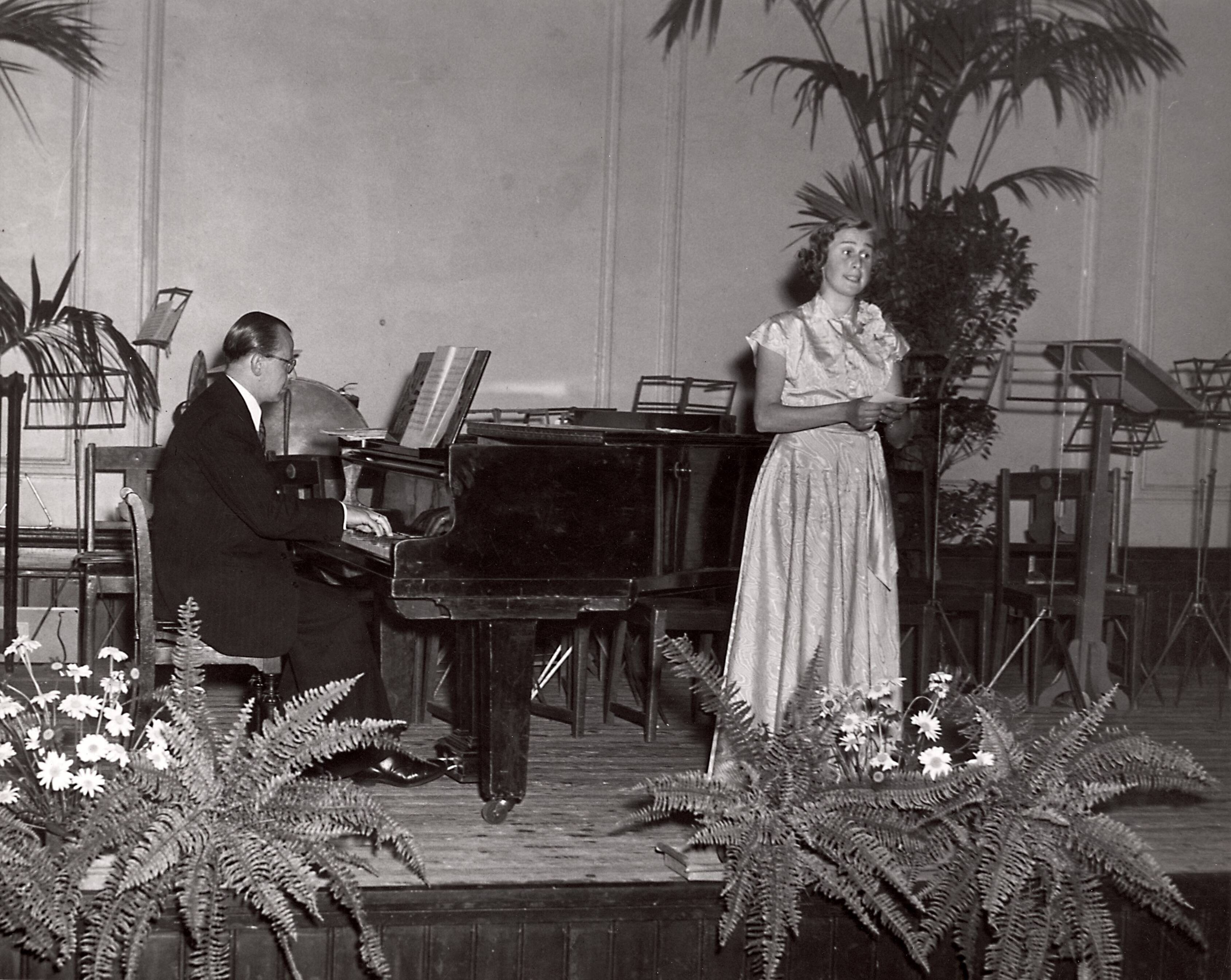 Collectie nader te bepalen — [Harmonie "Amphion" van Drukkerij N.V. Spaarnestad] [zangeres en pianist op podium] — Foto: Fotograaf Onbekend / Fotobureau onbekend / Spaarnestad Photo (05887). Licentie: Set B: Rechtenvrij / Publiek Domein. Bron: Nationaal Archief. http://hdl.handle.net/10648/35429da6-3c4e-a382-e063-6df0900a6686