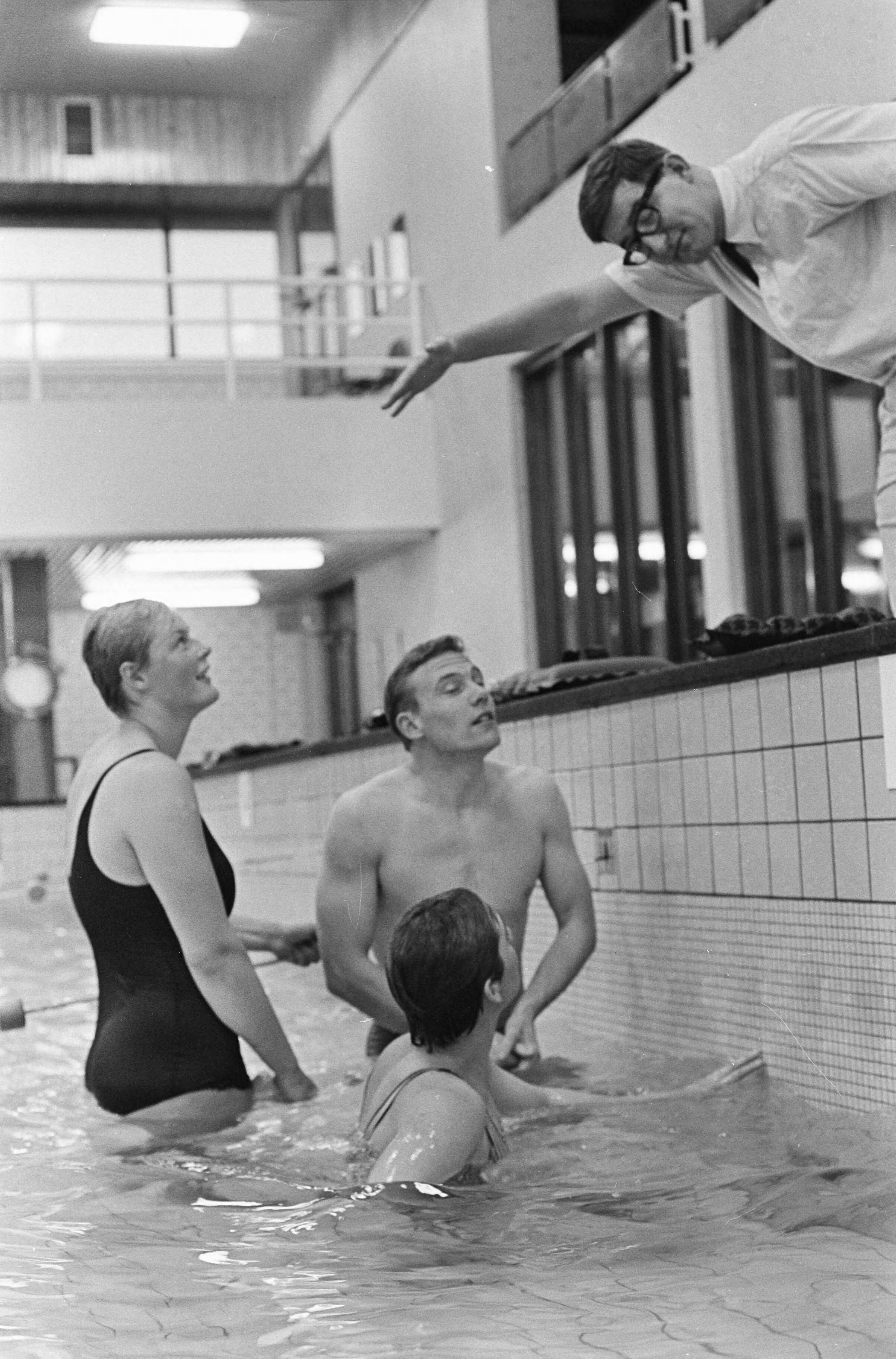 Fotocollectie Anefo — Nederlandse zwemploeg traint onder leiding van Rob Kerkhoven, v.l.n.r. Betty Heukels, Ada Kok en Jan Jiskoot die luisteren naar Kerkhoven — Foto: Kroon, Ron / Anefo. Licentie: Set B: Rechtenvrij / Publiek Domein. Bron: Nationaal Archief. http://hdl.handle.net/10648/aad83b02-d0b4-102d-bcf8-003048976d84