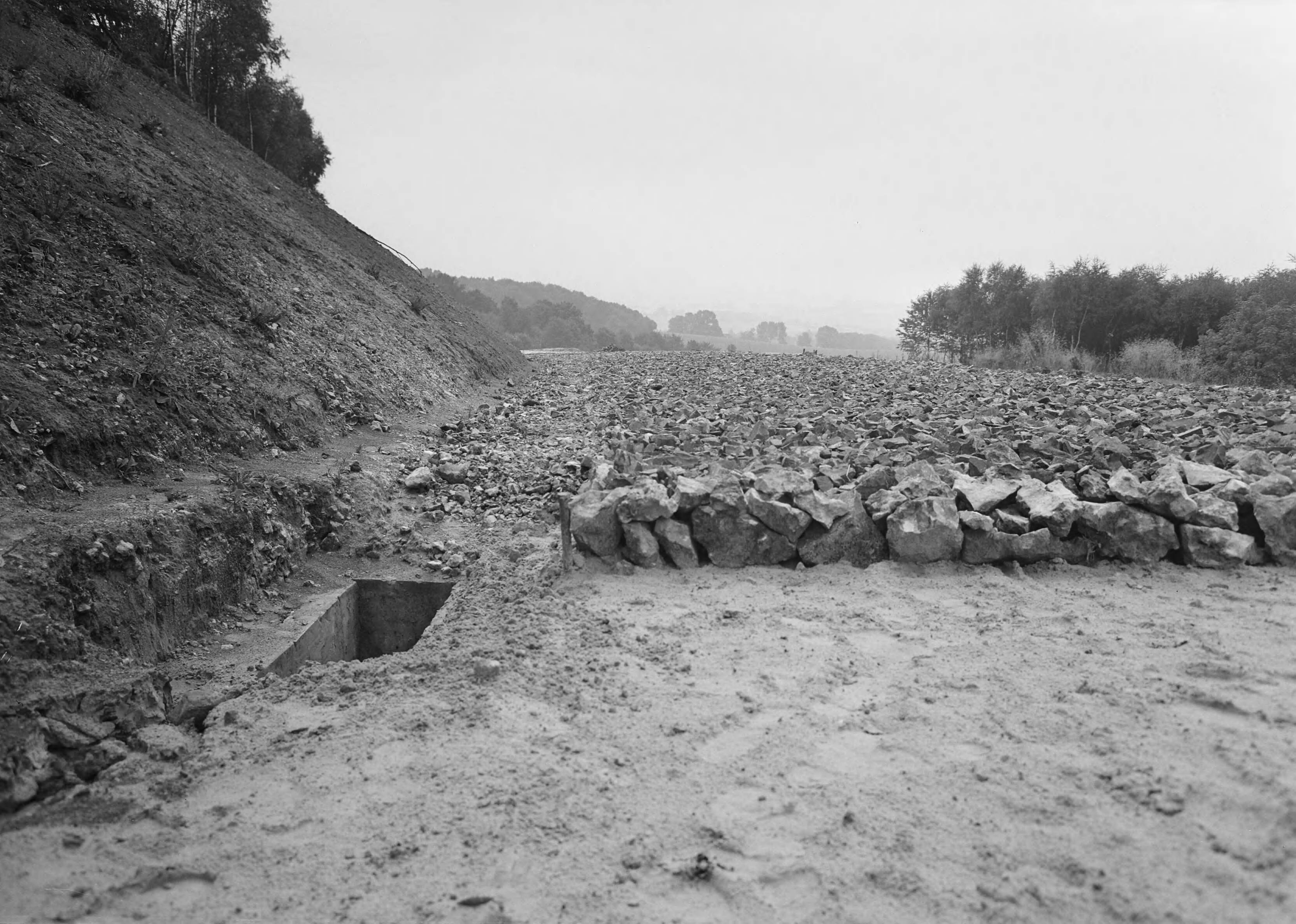 Fotocollectie Nederlandse Heidemaatschappij — Aanleg recreatieweg door Vijlenerbos Vaals. Gezette paklaag van Belg. Blauwsteen op zandbed met drainageput — Foto: Eyssen, [...] / Heidemij. Licentie: Set B: Rechtenvrij / Publiek Domein. Bron: Nationaal Archief. http://hdl.handle.net/10648/ae6fa12e-d0b4-102d-bcf8-003048976d84