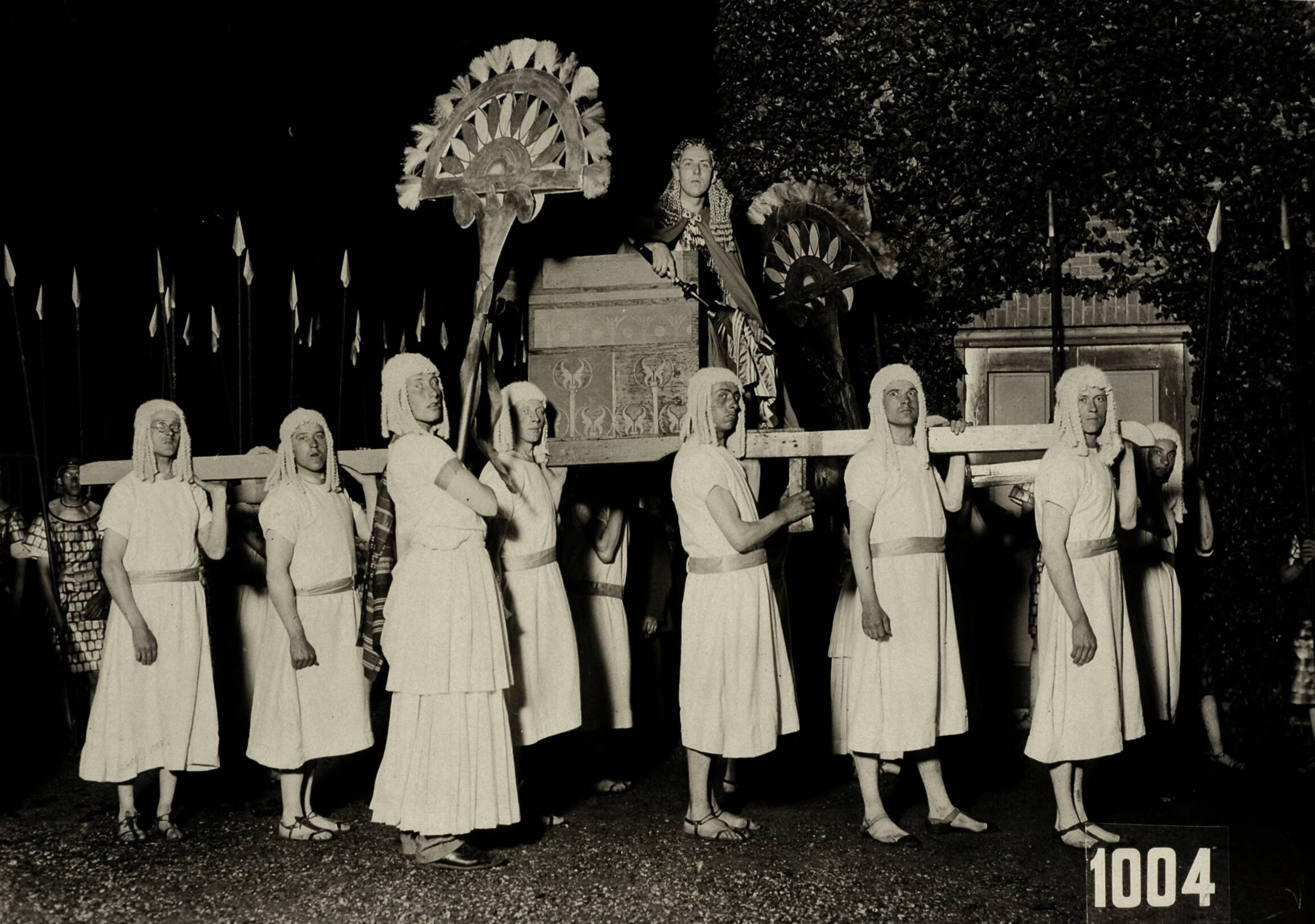 Sport — Sport. Olympische Spelen 1928 Amsterdam, Nederland : Een acteur als Oosterse vorst uitgedost in een draagstoel die door andere acteurs wordt gedragen tijdens de openluchtvoorstelling ihkv de kunstmanifestatie. — Foto: Fotograaf Onbekend / Algemeen Fotobureau Amsterdam / Spaarnestad Photo (05887). Licentie: Set B: Rechtenvrij / Publiek Domein. Bron: Nationaal Archief. http://hdl.handle.net/10648/35429da6-d6b3-a382-e063-6df0900a6686