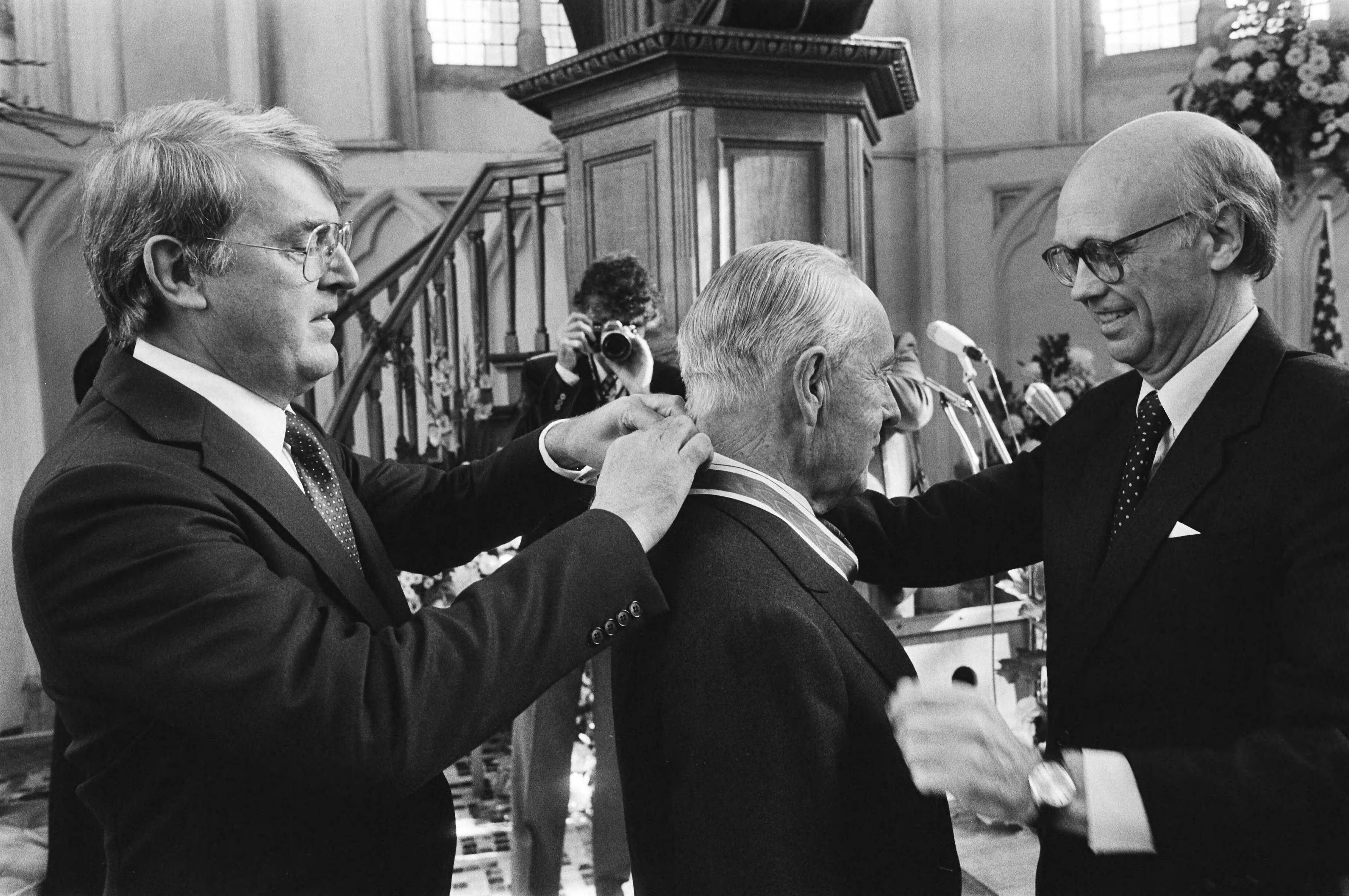 Uitreiking van de Four Freedoms Medals 1982 in Middelburg door leden van de Franklin D. Roosevelt Centennial Commission — Dr. J. H. van Roijen ontvangt de Freedom from Fear Award uit handen van Curtis Roosevelt. Links voormalig VN-ambassadeur W.J. van den Heuvel — Foto: Bogaerts, Rob / Anefo. Licentie: Set B: Rechtenvrij / Publiek Domein. Bron: Nationaal Archief. http://hdl.handle.net/10648/ad200ac0-d0b4-102d-bcf8-003048976d84
