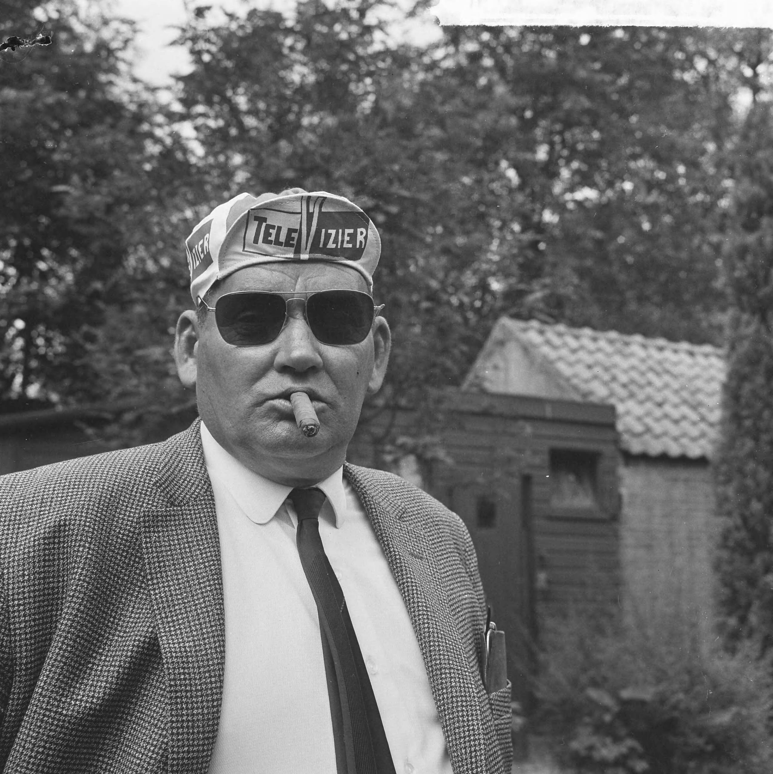 Fotocollectie Anefo — Televizierploeg voor de Tour de France in Hotel De Zwaan te Etten voorgesteld, ploegleider Kees Pellenaars (met zonnebril en sigaar) — Foto: Evers, Joost / Anefo. Licentie: Set B: Rechtenvrij / Publiek Domein. Bron: Nationaal Archief. http://hdl.handle.net/10648/aaadbe90-d0b4-102d-bcf8-003048976d84