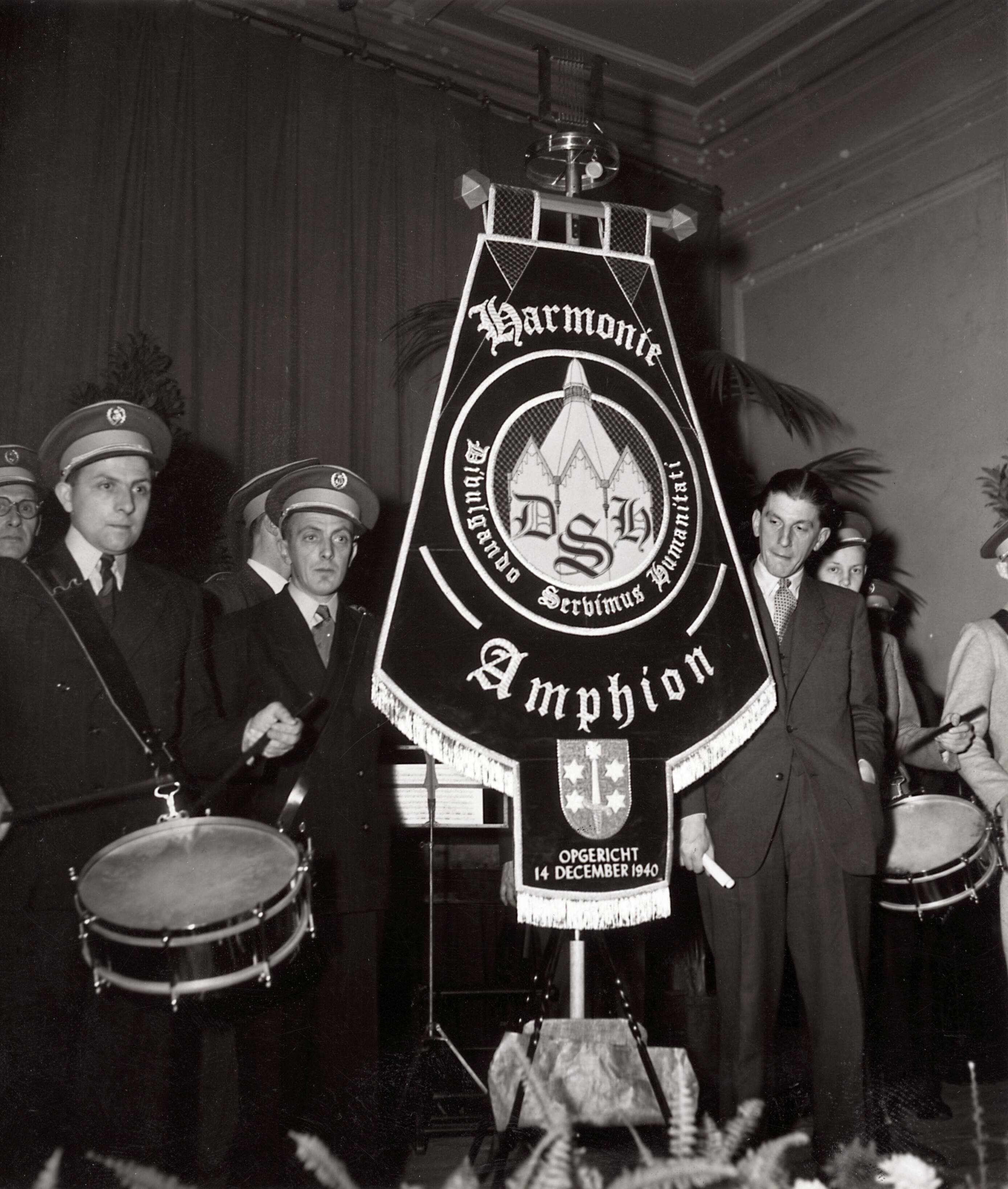 Cultuur — [Harmonie "Amphion" van Drukkerij N.V. Spaarnestad] [vaandel met motto "Divulgando . Servimus . Humanitatit" — Foto: Fotograaf Onbekend / Fotobureau onbekend / Spaarnestad Photo (05887). Licentie: Set B: Rechtenvrij / Publiek Domein. Bron: Nationaal Archief. http://hdl.handle.net/10648/35429da6-3c45-a382-e063-6df0900a6686