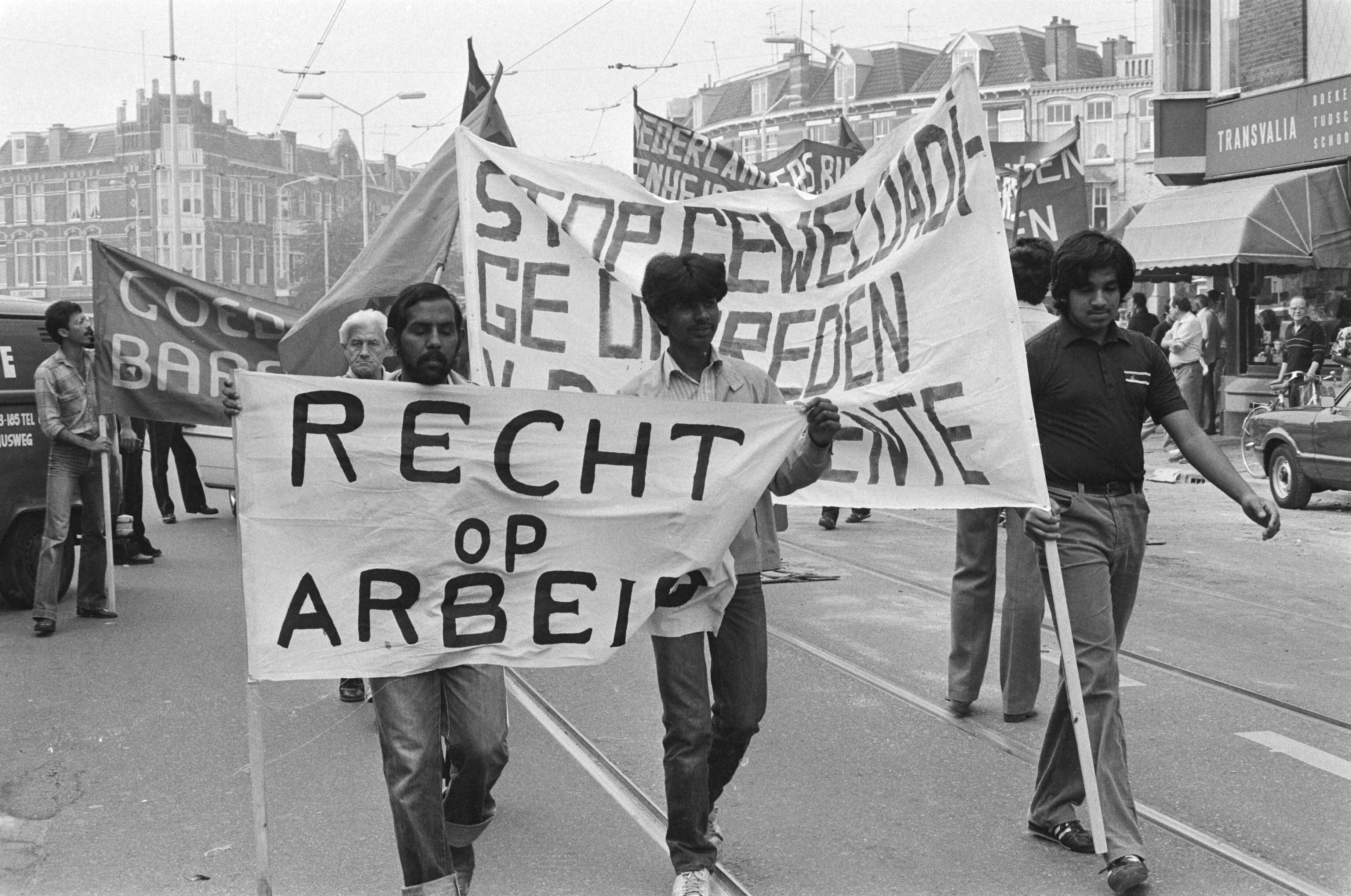 Surinamers demonstreren tegen het gemeentebeleid in Den Haag — Demonstranten met spandoeken — Foto: Dijk, Hans van / Anefo. Licentie: Set B: Rechtenvrij / Publiek Domein. Bron: Nationaal Archief. http://hdl.handle.net/10648/ad1ea1b2-d0b4-102d-bcf8-003048976d84