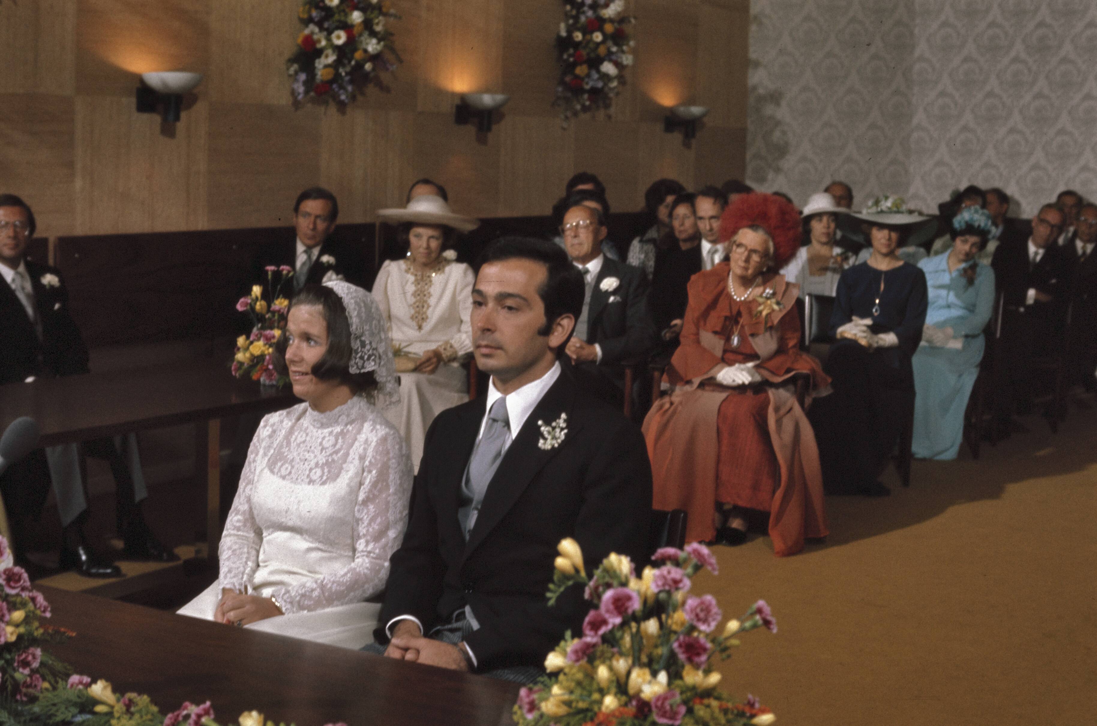 Fotocollectie Anefo — Burgelijk huwelijk Prinses Christina en Jorge Guillermo in Stadhuis in Baarn; zittend in trouwzaal met Koninklijke Familie en genodigden / — Foto: Mieremet, Rob / Anefo. Licentie: Set B: Rechtenvrij / Publiek Domein. Bron: Nationaal Archief. http://hdl.handle.net/10648/ad9391b6-d0b4-102d-bcf8-003048976d84