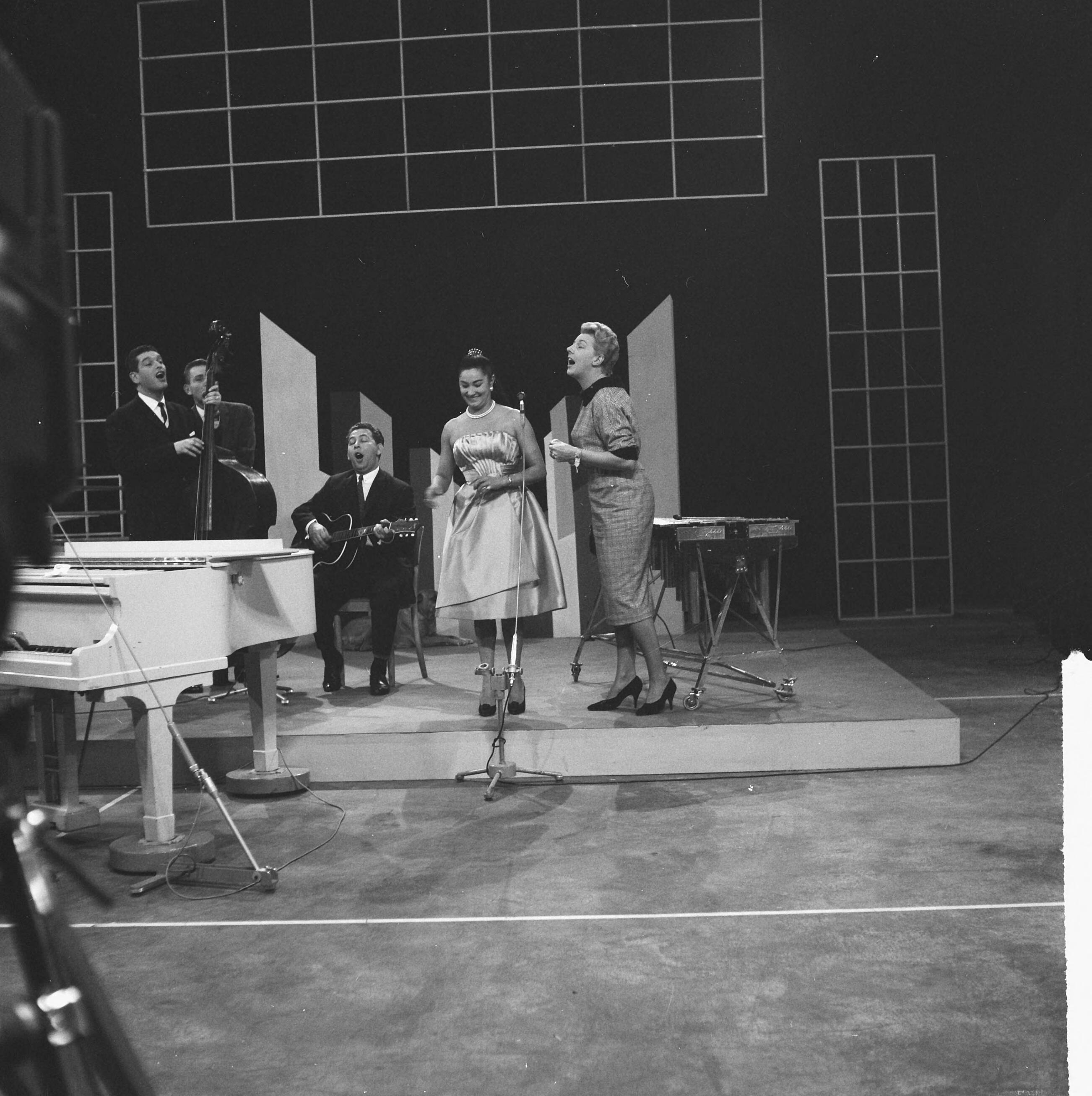 Fotocollectie Anefo — Televisieprogramma "TV-Toto" van de VARA uitgezonden vanuit de Expohal, Sanny Day (oud-zangeres van de Millers) zingt met Pia Beck (rechts) en worden begeleid door de Millers — Foto: Lindeboom, Henk / Anefo. Licentie: Set B: Rechtenvrij / Publiek Domein. Bron: Nationaal Archief. http://hdl.handle.net/10648/a9c24442-d0b4-102d-bcf8-003048976d84