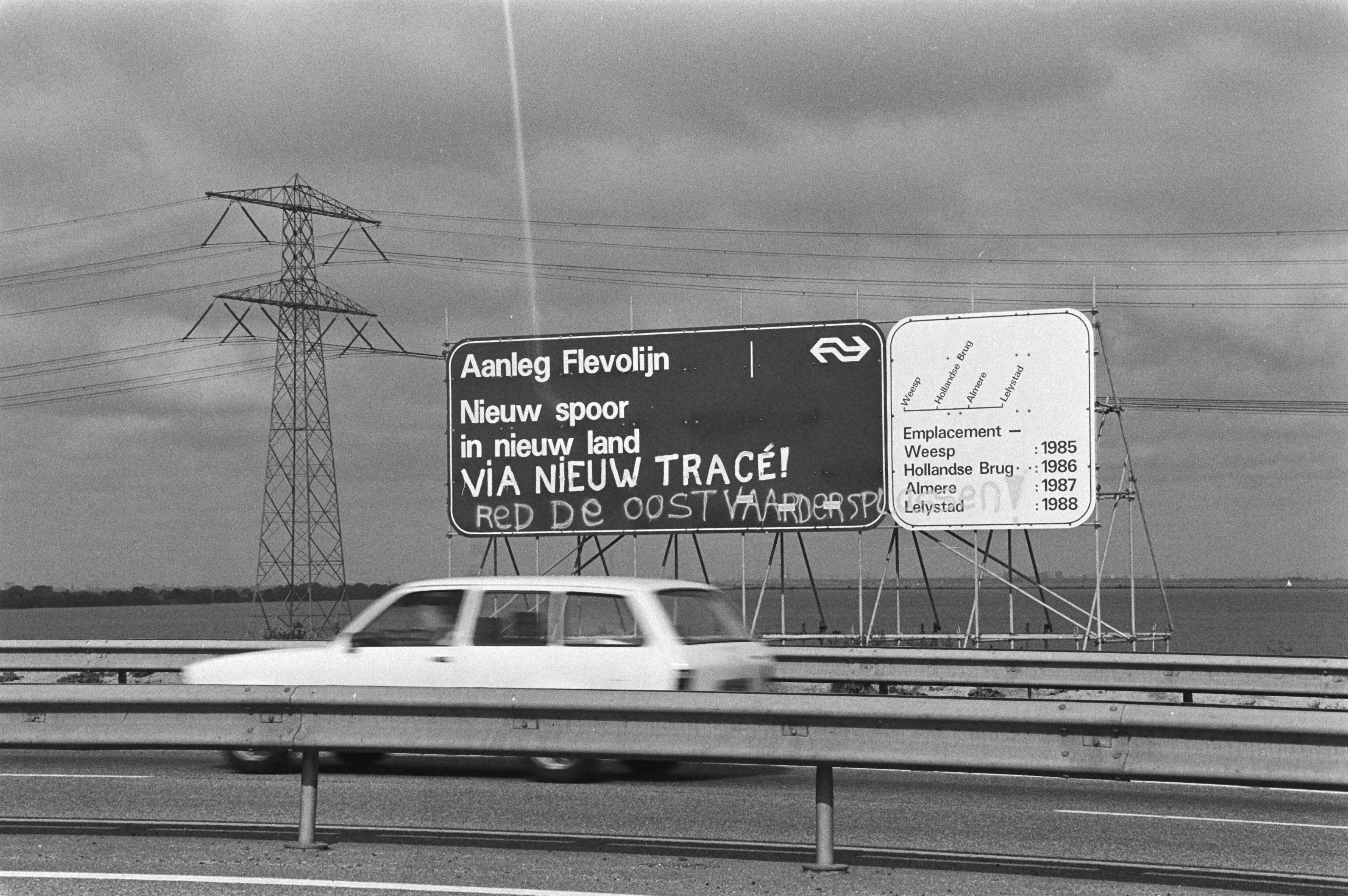 Fotocollectie Anefo — Protest met betrekking tot de bouw van de Flevolijn door de Oostvaardersplassen op een bord van de Nederlandse Spoorwegen op de Hollandse brug bij Almere — Foto: Dijk, Hans van / Anefo. Licentie: Set B: Rechtenvrij / Publiek Domein. Bron: Nationaal Archief. http://hdl.handle.net/10648/ad02d41e-d0b4-102d-bcf8-003048976d84