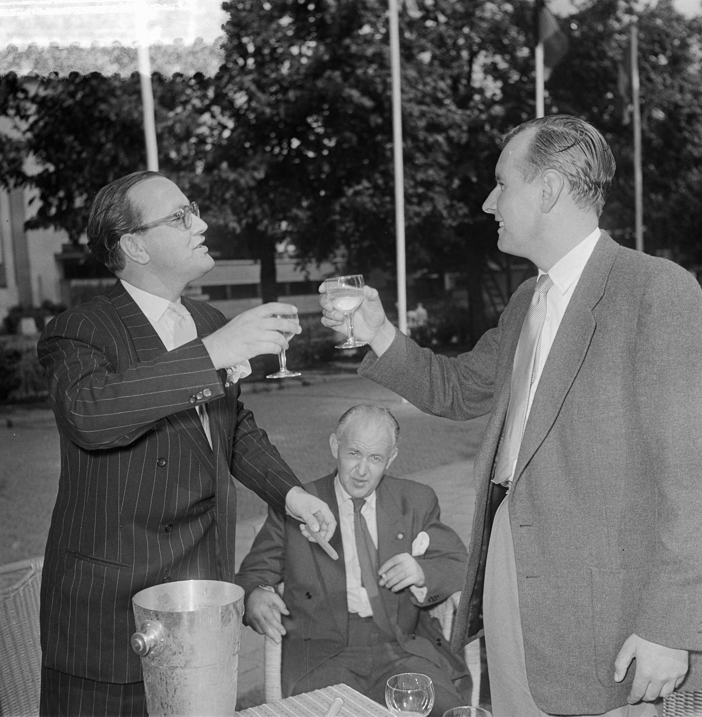 Fotocollectie Anefo — Ger de Roos (rechts) en Carel Briels toasten met champagne in Hilversum — Foto: Noske, J.D. / Anefo. Licentie: Set B: Rechtenvrij / Publiek Domein. Bron: Nationaal Archief. http://hdl.handle.net/10648/a911face-d0b4-102d-bcf8-003048976d84