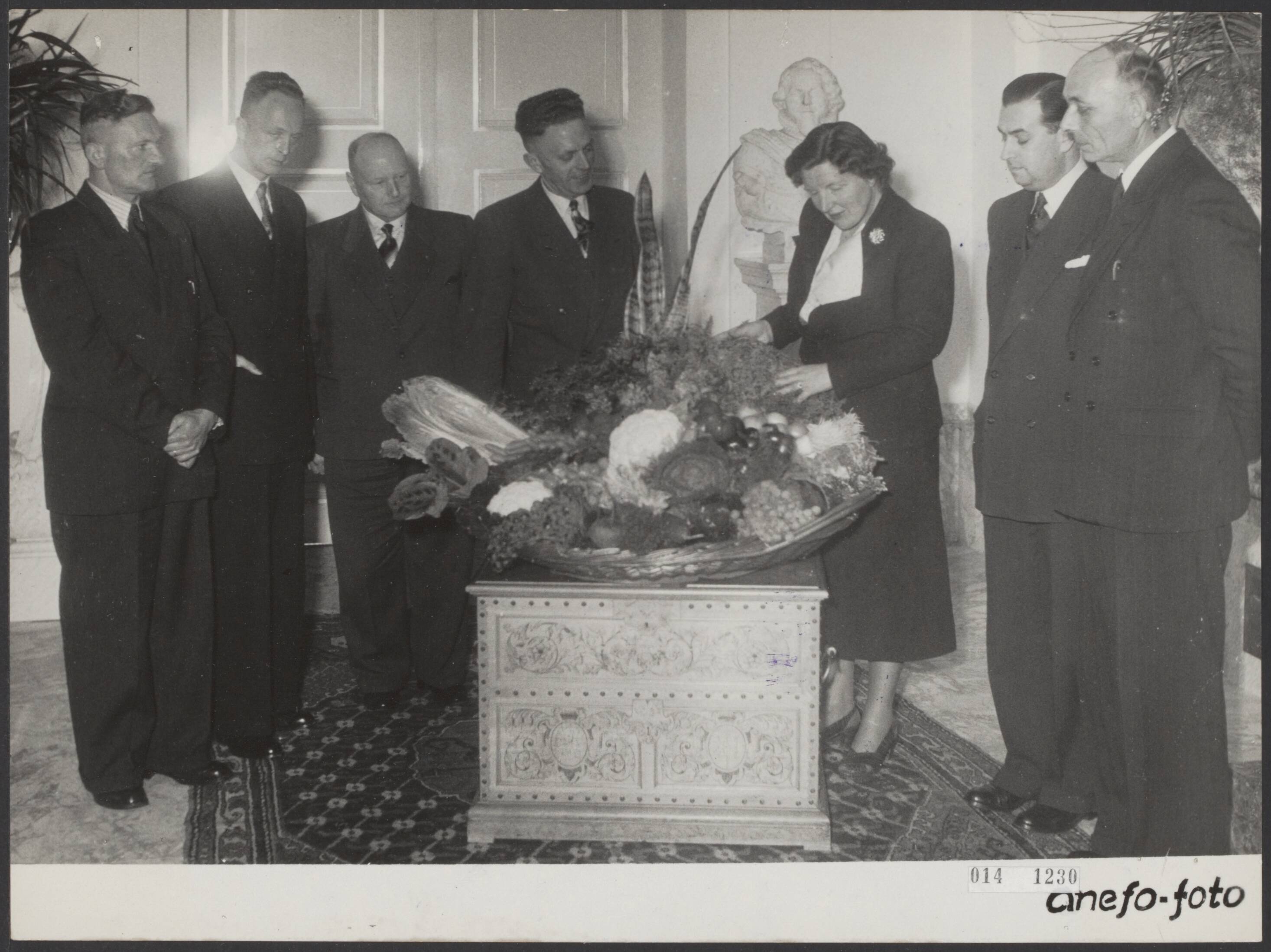 Fotocollectie Elsevier Binnenland — Aanbieden van een mand met tuinbouwproducten door de veilingvereniging "De Tuinbouw" uit Grootebroek aan koningin Juliana op paleis Soestdijk. 2e van rechts P.J. Cramwinckel (burgemeester van Grootebroek). In het midden veilingvoorzitter A.J. de Boer. "De Tuinbouw" is een der oudste veilingverenigingen van ons land en bestaat in 1952 60 jaar — Foto: Noske, J.D. / Anefo. Licentie: Set B: Rechtenvrij / Publiek Domein. Bron: Nationaal Archief. http://hdl.handle.net/10648/adb32594-d0b4-102d-bcf8-003048976d84