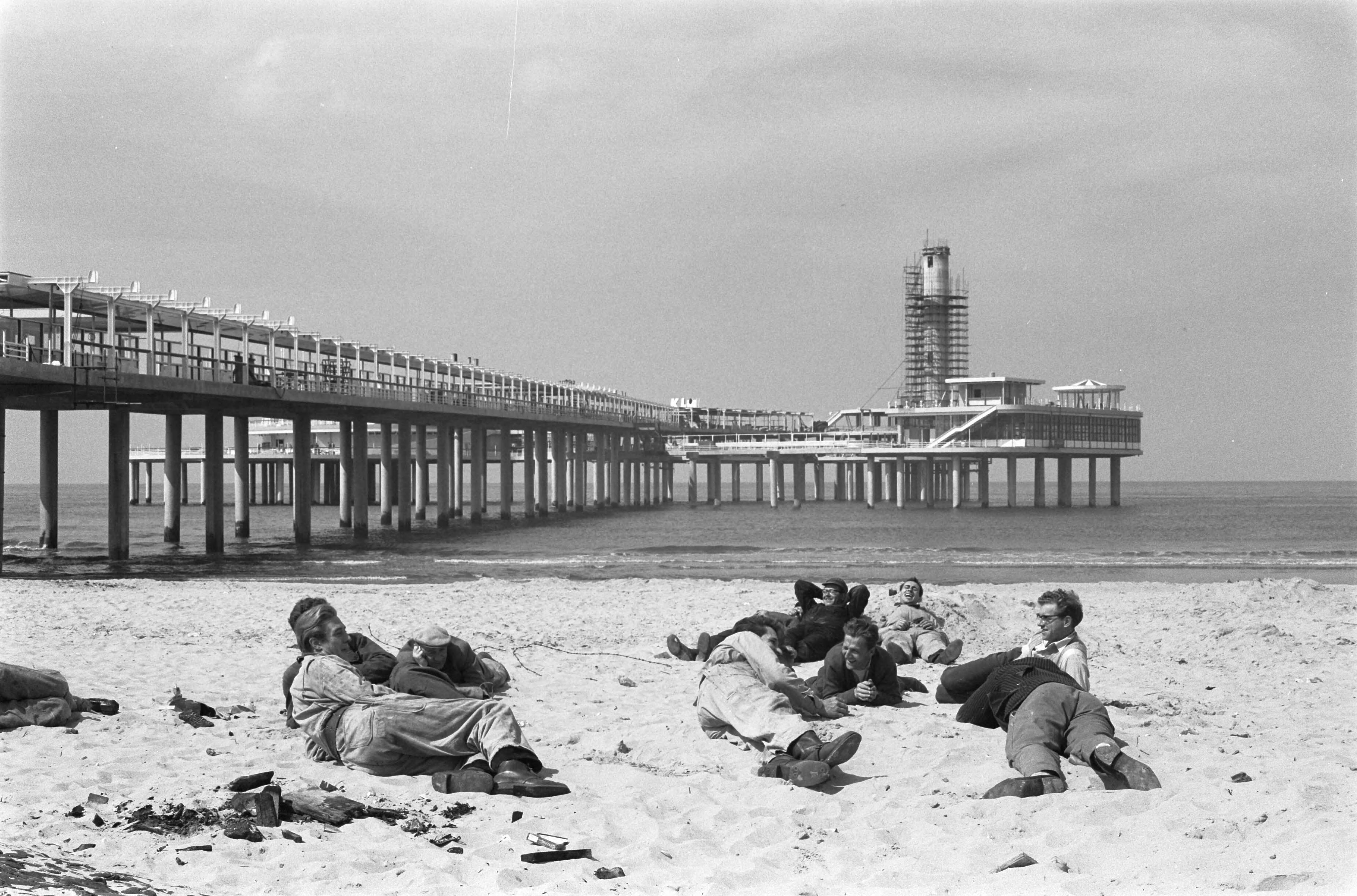 Fotocollectie Anefo — De nieuwe Pier in Scheveningen. Strandbeeld met in de achtergrond de nieuwe pier in aanbouw — Foto: Pot, Harry / Anefo. Licentie: Set B: Rechtenvrij / Publiek Domein. Bron: Nationaal Archief. http://hdl.handle.net/10648/a9d2e05e-d0b4-102d-bcf8-003048976d84