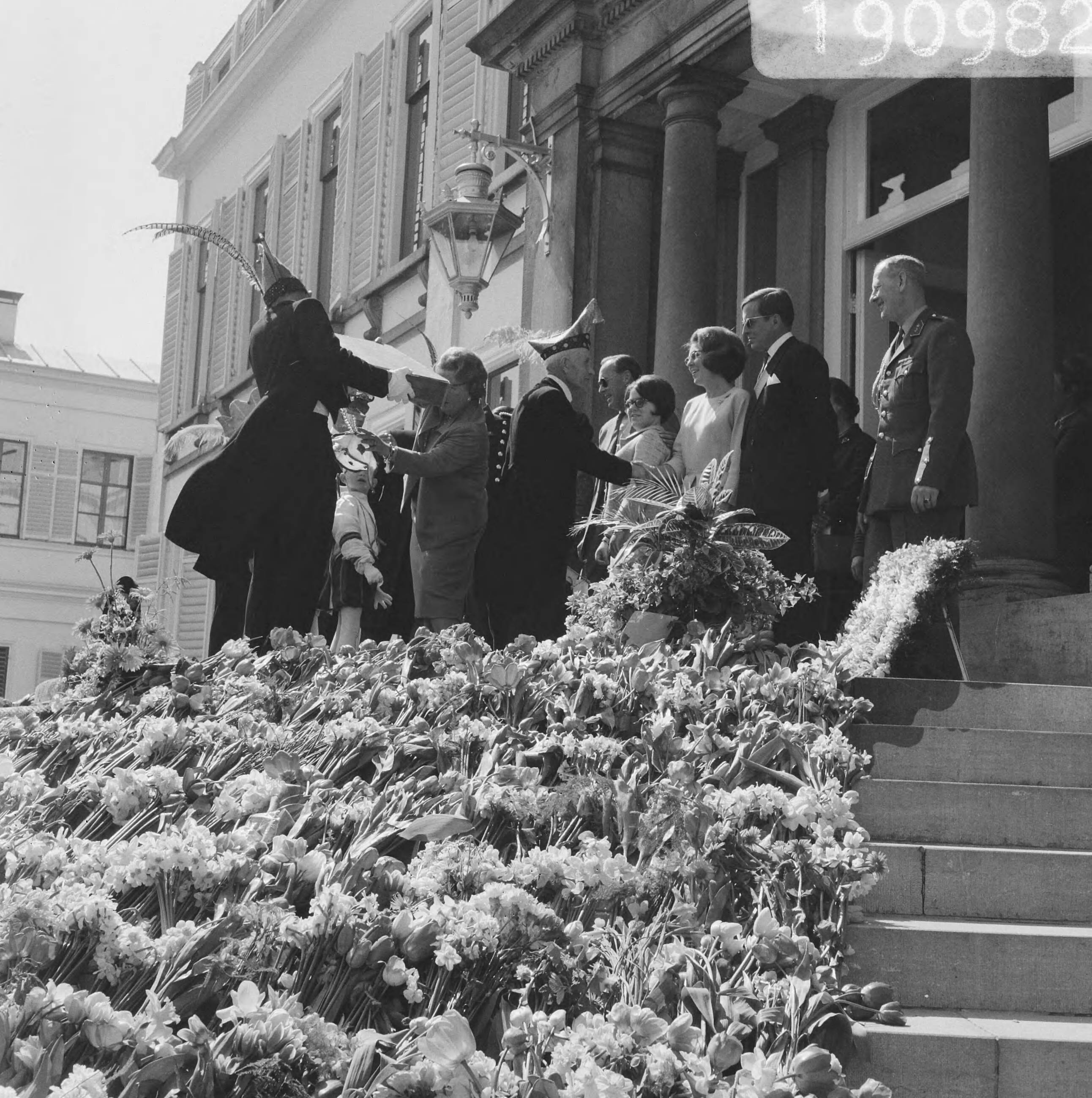 Fotocollectie Anefo — Koninginnedag, defilee op Soestdijk, carnavalsvereniging biedt iets aan — Foto: Kroon, Ron / Anefo. Licentie: Set B: Rechtenvrij / Publiek Domein. Bron: Nationaal Archief. http://hdl.handle.net/10648/aae80fd2-d0b4-102d-bcf8-003048976d84