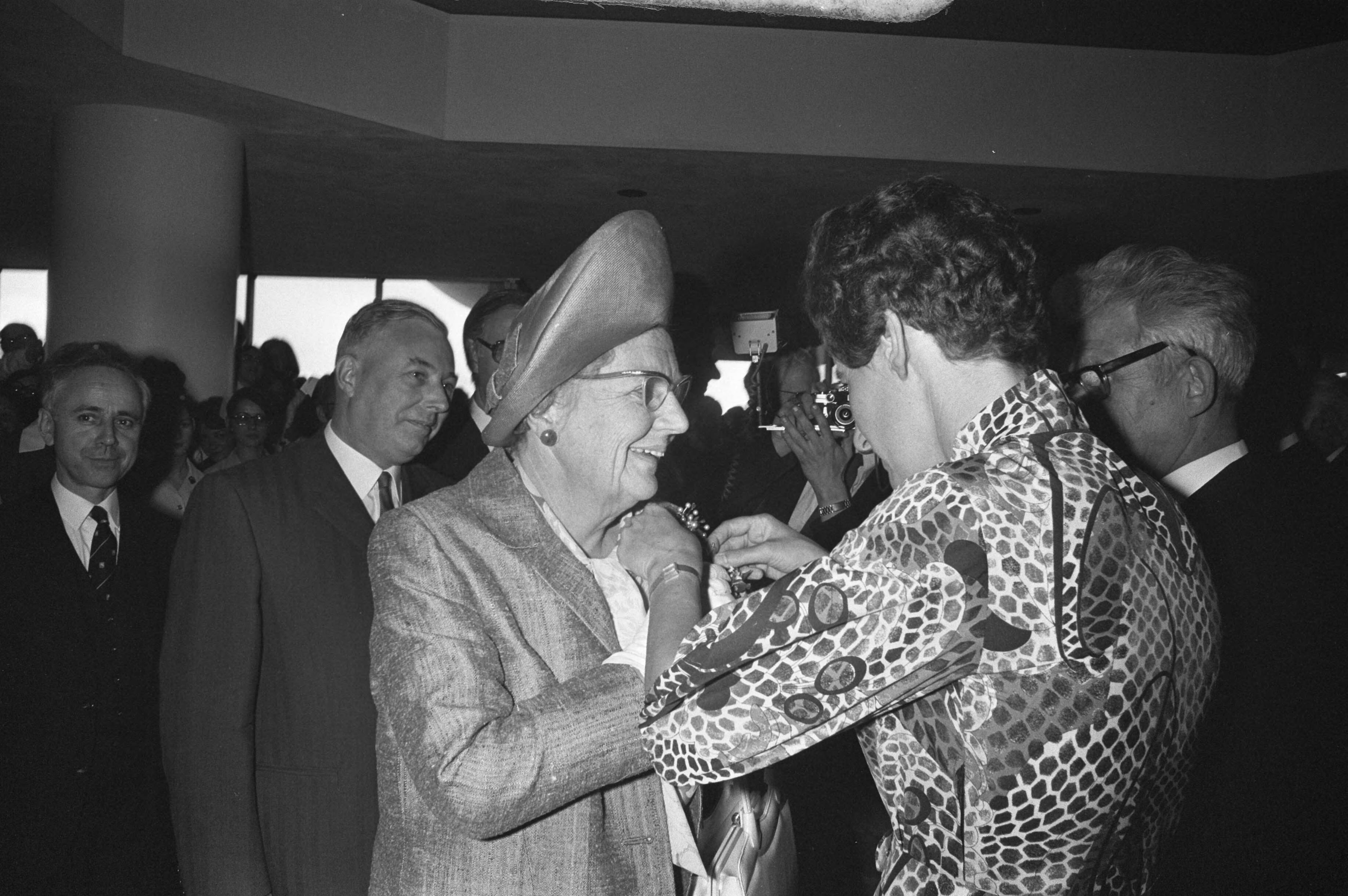 Opening van het ziekenhuiscomplex Leyenburg in Den Haag door Hare Majesteit koningin Juliana — De koningin krijgt iets opgespeld — Foto: Fotograaf Onbekend / Anefo. Licentie: Set B: Rechtenvrij / Publiek Domein. Bron: Nationaal Archief. http://hdl.handle.net/10648/abe98974-d0b4-102d-bcf8-003048976d84