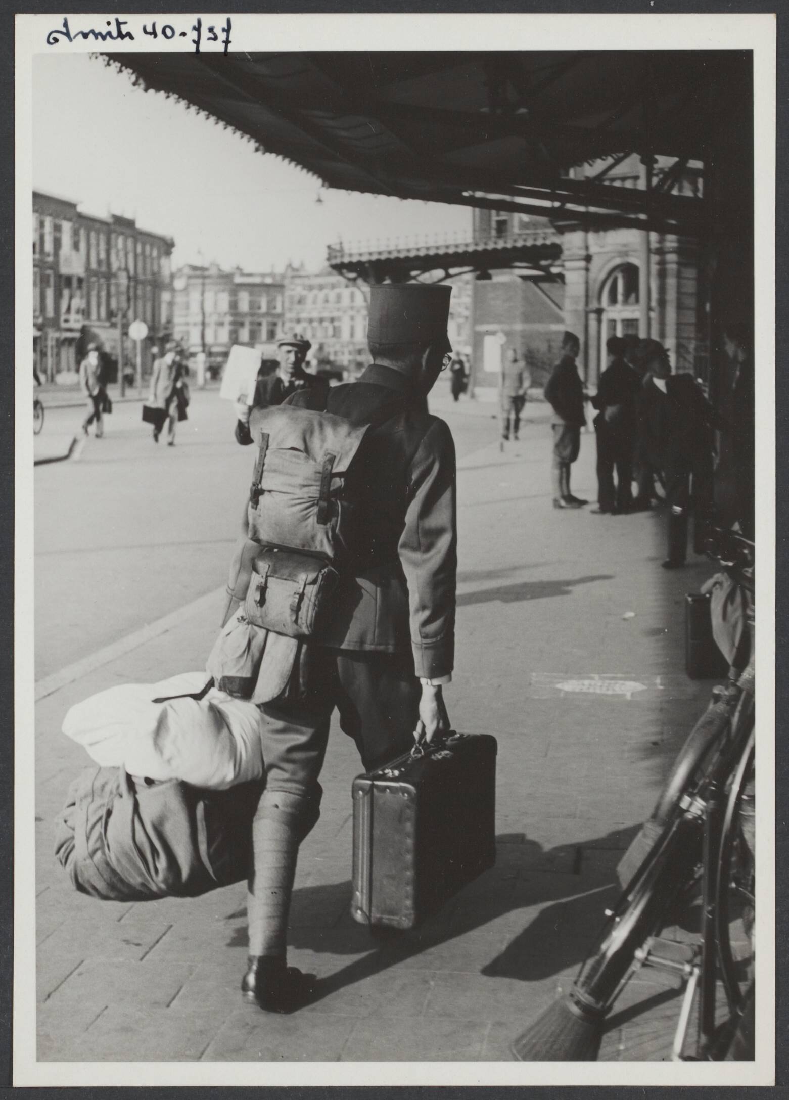 Demobilisatie 1940 — Serie: Demobilisatie Den Haag [Een militair keert bepakt en bezakt huiswaarts tijdens de demobilisatie van de Nederlandse troepen in 1940 [station Hollands Spoor in Den Haag].] — Foto: Smits, Roeland Pieter / Spaarnestad. Licentie: Set B: Rechtenvrij / Publiek Domein. Bron: Nationaal Archief. http://hdl.handle.net/10648/e08a1984-30a3-1a45-eef1-d4f7fe04959f