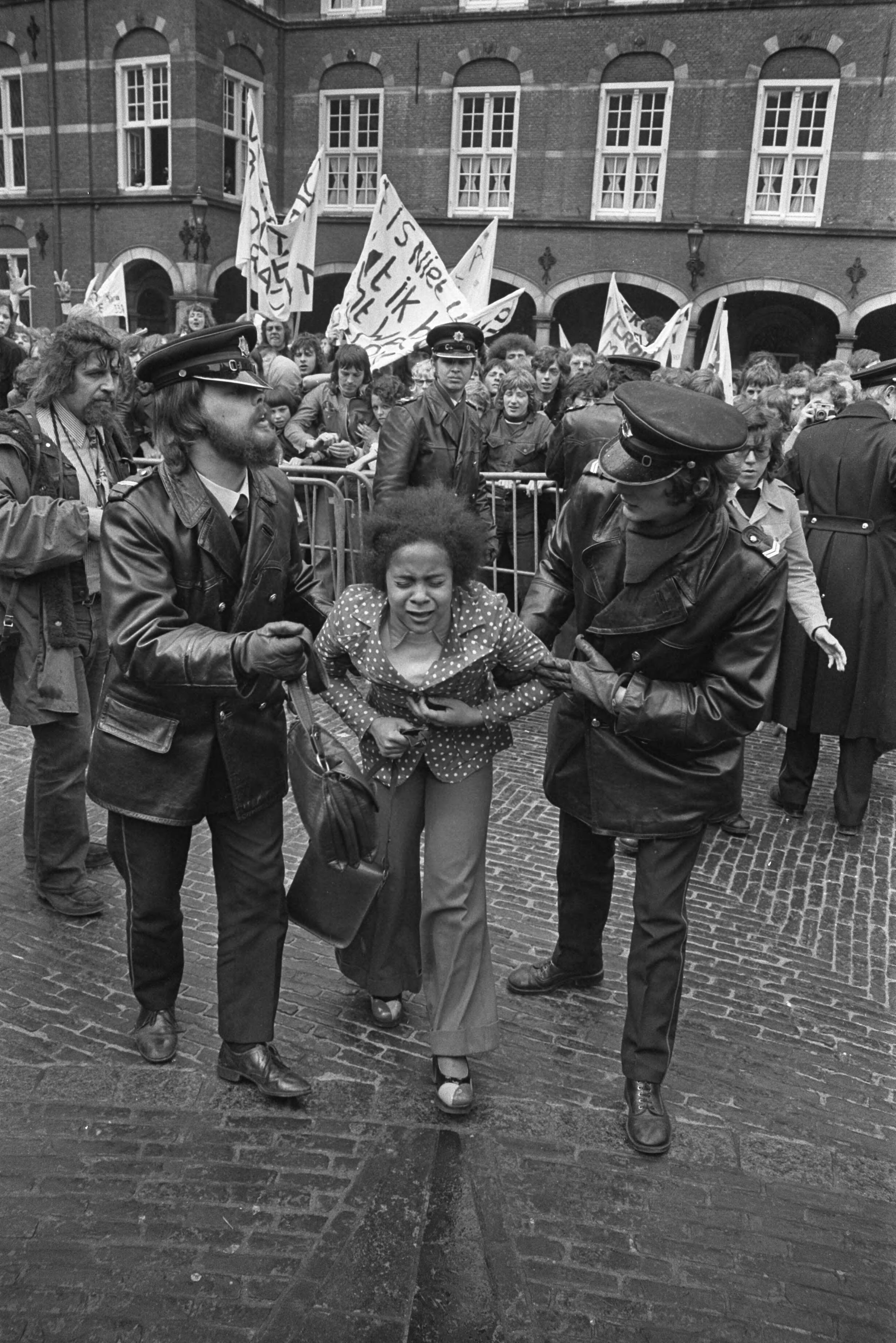 Fotocollectie Anefo — Demonstratie en hoorzitting over Veronica in Den Haag , gewond meisje wordt weggeleid door agent — Foto: Verhoeff, Bert / Anefo. Licentie: Set B: Rechtenvrij / Publiek Domein. Bron: Nationaal Archief. http://hdl.handle.net/10648/ac2a3528-d0b4-102d-bcf8-003048976d84