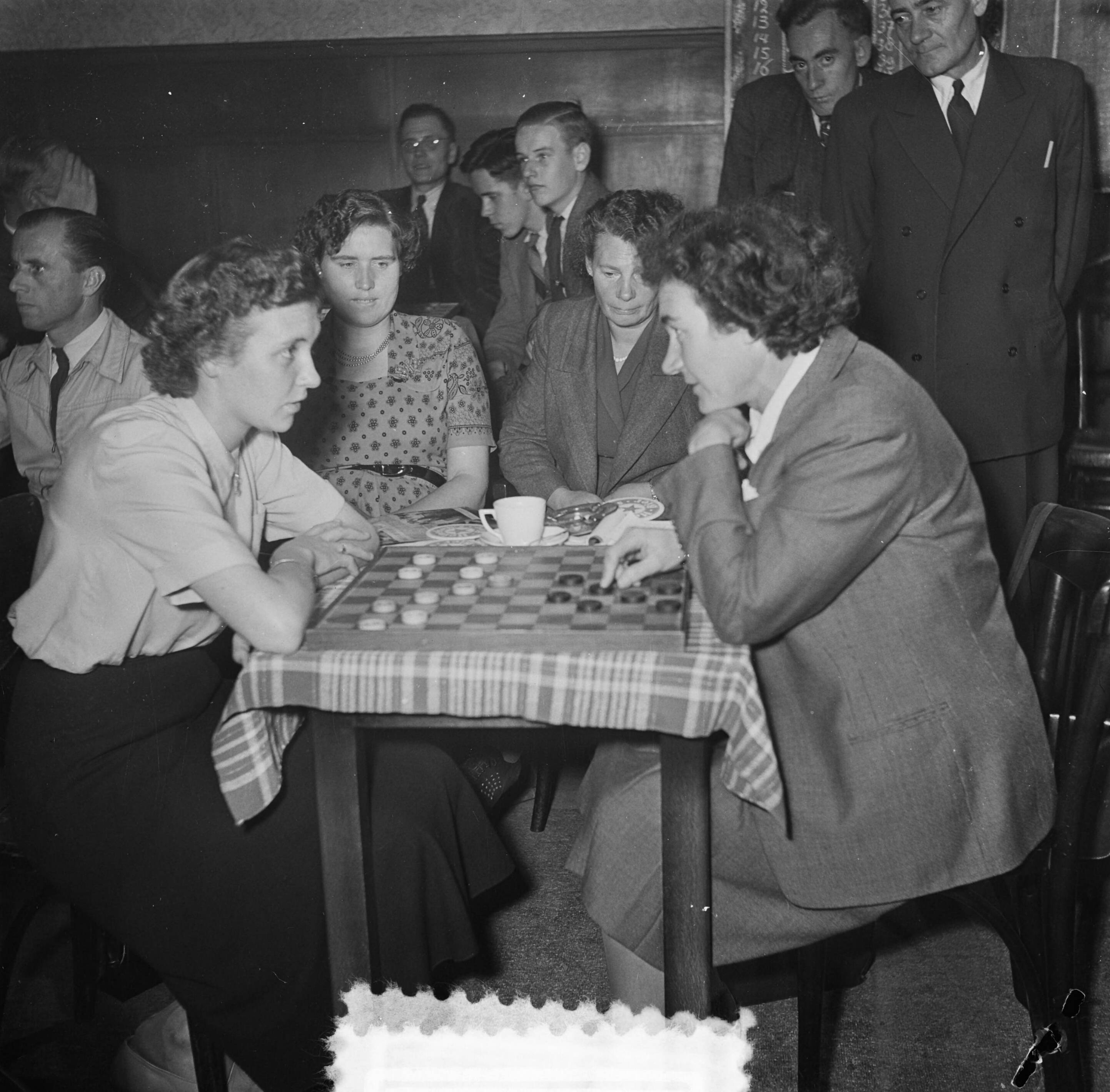 Fotocollectie Anefo — Tweekamp wereldkampioenschap dammen tussen R.C. Keller en P. Roozenbrug. Mevrouw Keller, echtgenote van R.C. Keller ,speelt tegen mejuffrouw Heiligers — Foto: Noske, J.D. / Anefo. Licentie: Set B: Rechtenvrij / Publiek Domein. Bron: Nationaal Archief. http://hdl.handle.net/10648/a8efed30-d0b4-102d-bcf8-003048976d84
