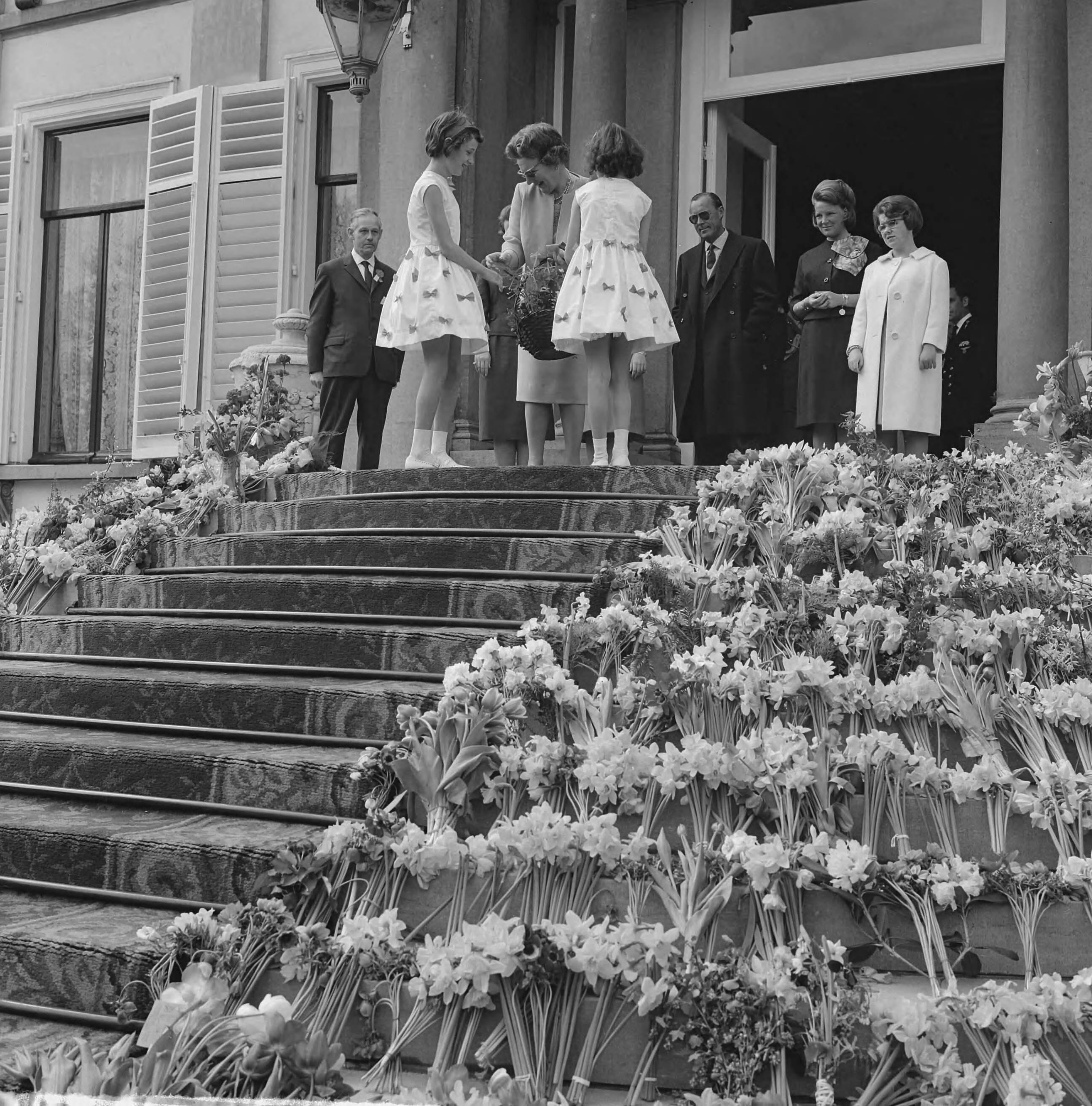 Koninginnedag 1963 — Koningin Juliana krijgt bloemen aangeboden — Foto: Nijs, Jac. de / Anefo. Licentie: Set B: Rechtenvrij / Publiek Domein. Bron: Nationaal Archief. http://hdl.handle.net/10648/aa34a280-d0b4-102d-bcf8-003048976d84