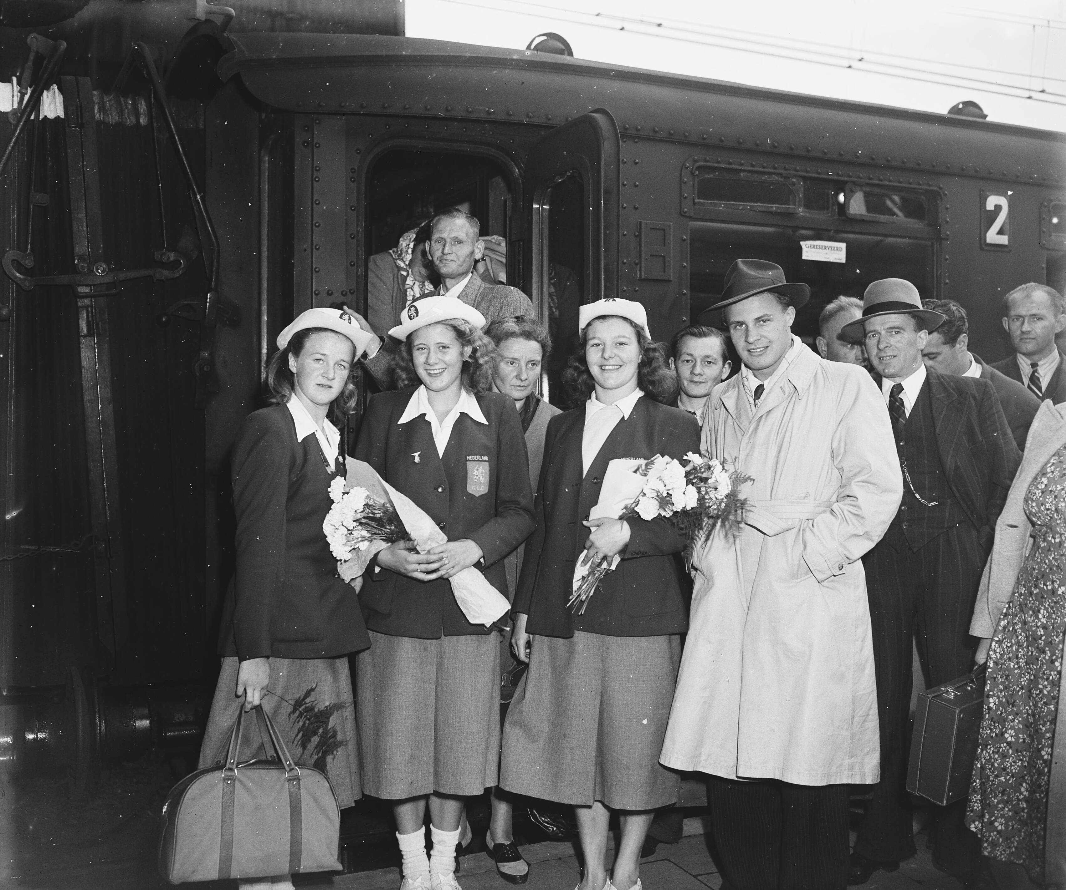 Fotocollectie Anefo — Nel Van Vliet gehuldigd in Hilversum. Aankomst op spoorstation met Tonny Hom en Dicky van Ekris — Foto: Snikkers, Anton / Anefo. Licentie: Set B: Rechtenvrij / Publiek Domein. Bron: Nationaal Archief. http://hdl.handle.net/10648/a8bb1d80-d0b4-102d-bcf8-003048976d84