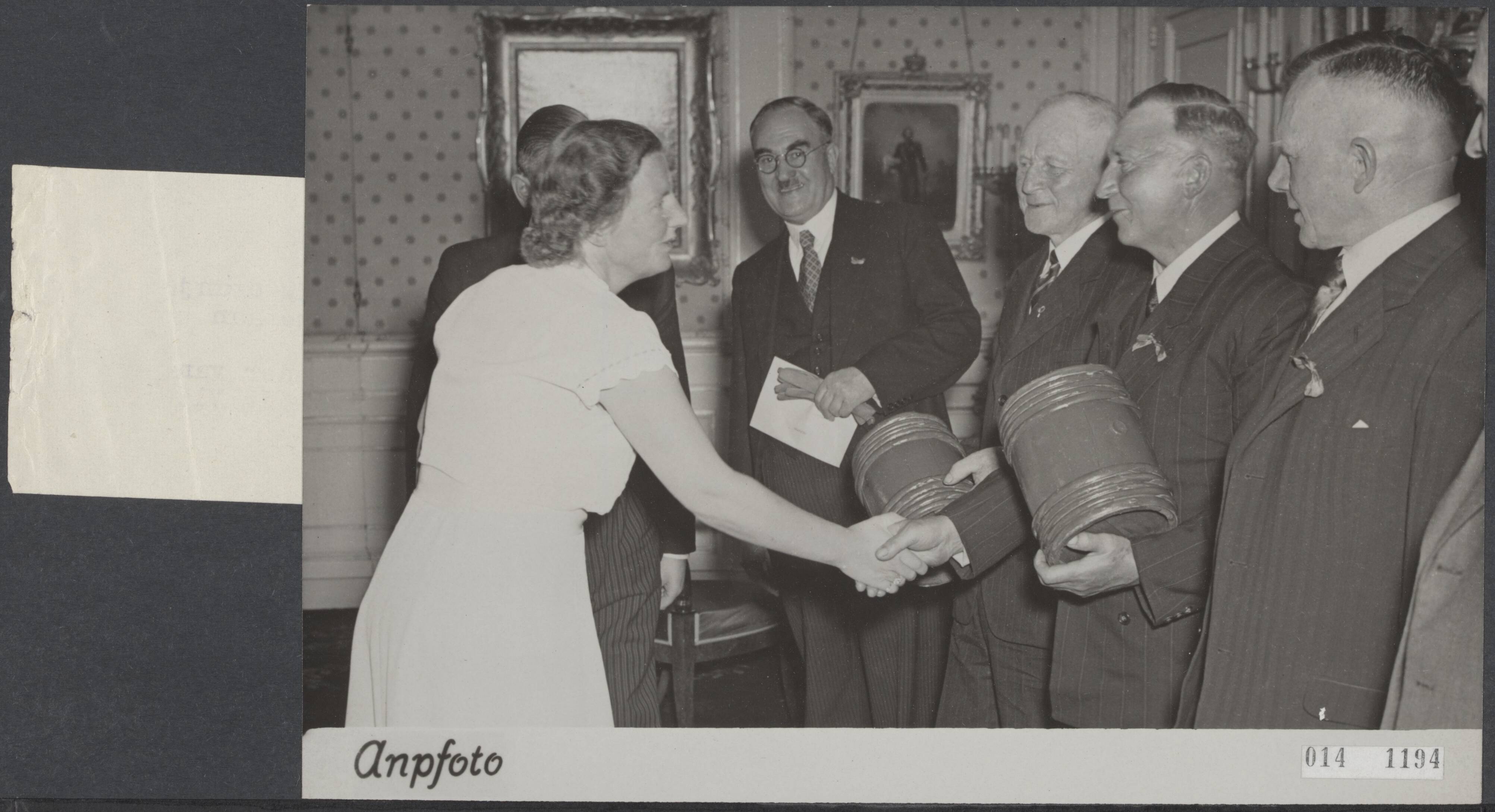 Fotocollectie Elsevier Binnenland — Een met vlaggen versierde auto vervoerde oranje vaatjes Hollandse nieuwe naar paleis Soestdijk, waar ze aan koningin Juliana werden aangeboden. De delegatie Vlaardingers, vlnr. H. van Toor, reder van de firma C. van Toor, G. v.d. SChee en schipper J. Rog van de Vl. 61, tijdens de voorstelling aan de koningin — Foto: ANP / RVD of rechtenvrij. Licentie: Set B: Rechtenvrij / Publiek Domein. Bron: Nationaal Archief. http://hdl.handle.net/10648/adb309ce-d0b4-102d-bcf8-003048976d84