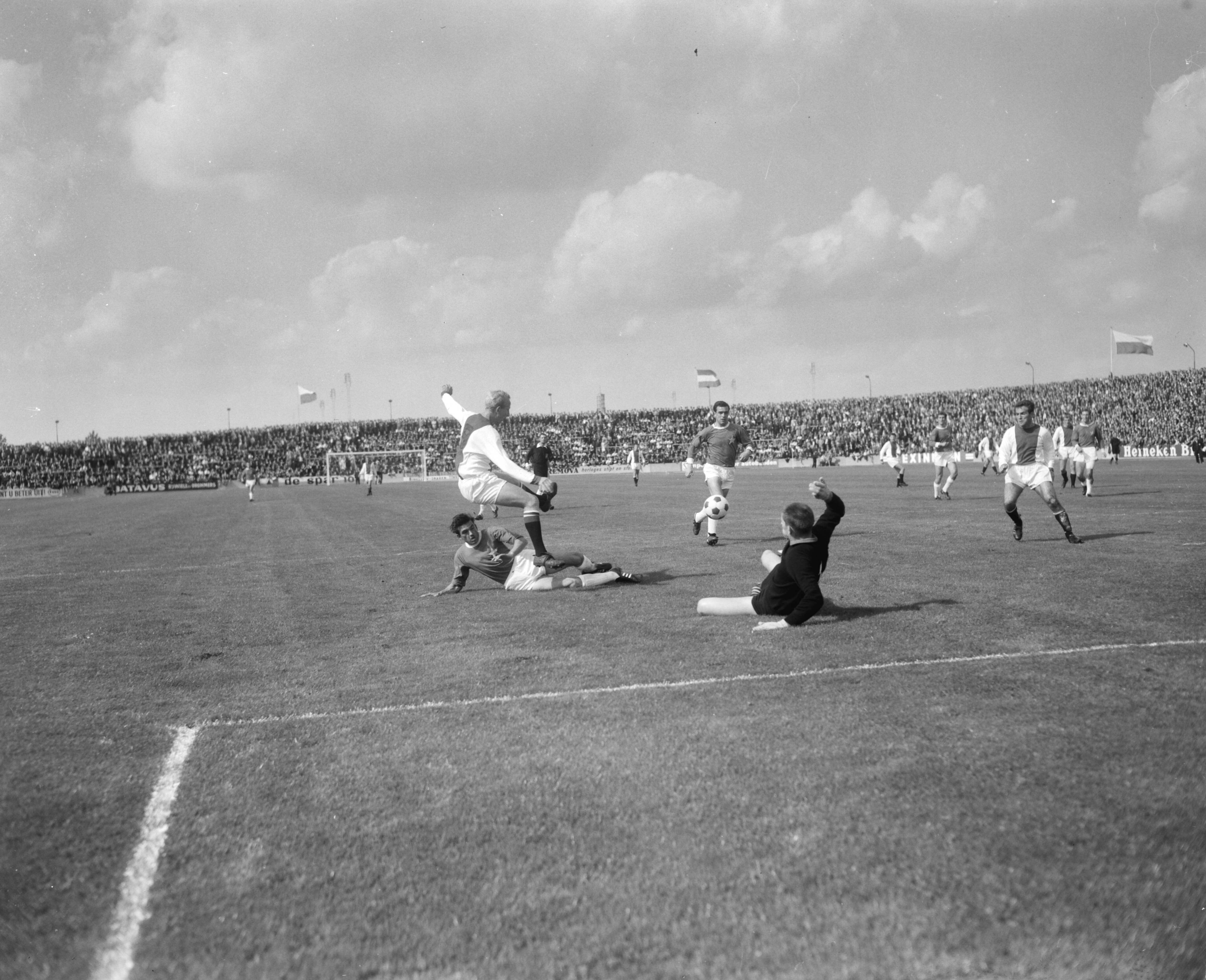 Fotocollectie Anefo — Voetbal. MVV-Ajax 0-1. Spelmoment, Ajax doelpunt gaat gescoord worden, links Henk Groot (Ajax) op de grond MVV-keeper Körver, rechts Bennie Muller (Ajax) die het doelpunt zou maken (in de 30e minuut) — Foto: Bilsen, Joop van / Anefo. Licentie: Set B: Rechtenvrij / Publiek Domein. Bron: Nationaal Archief. http://hdl.handle.net/10648/aabd98ec-d0b4-102d-bcf8-003048976d84