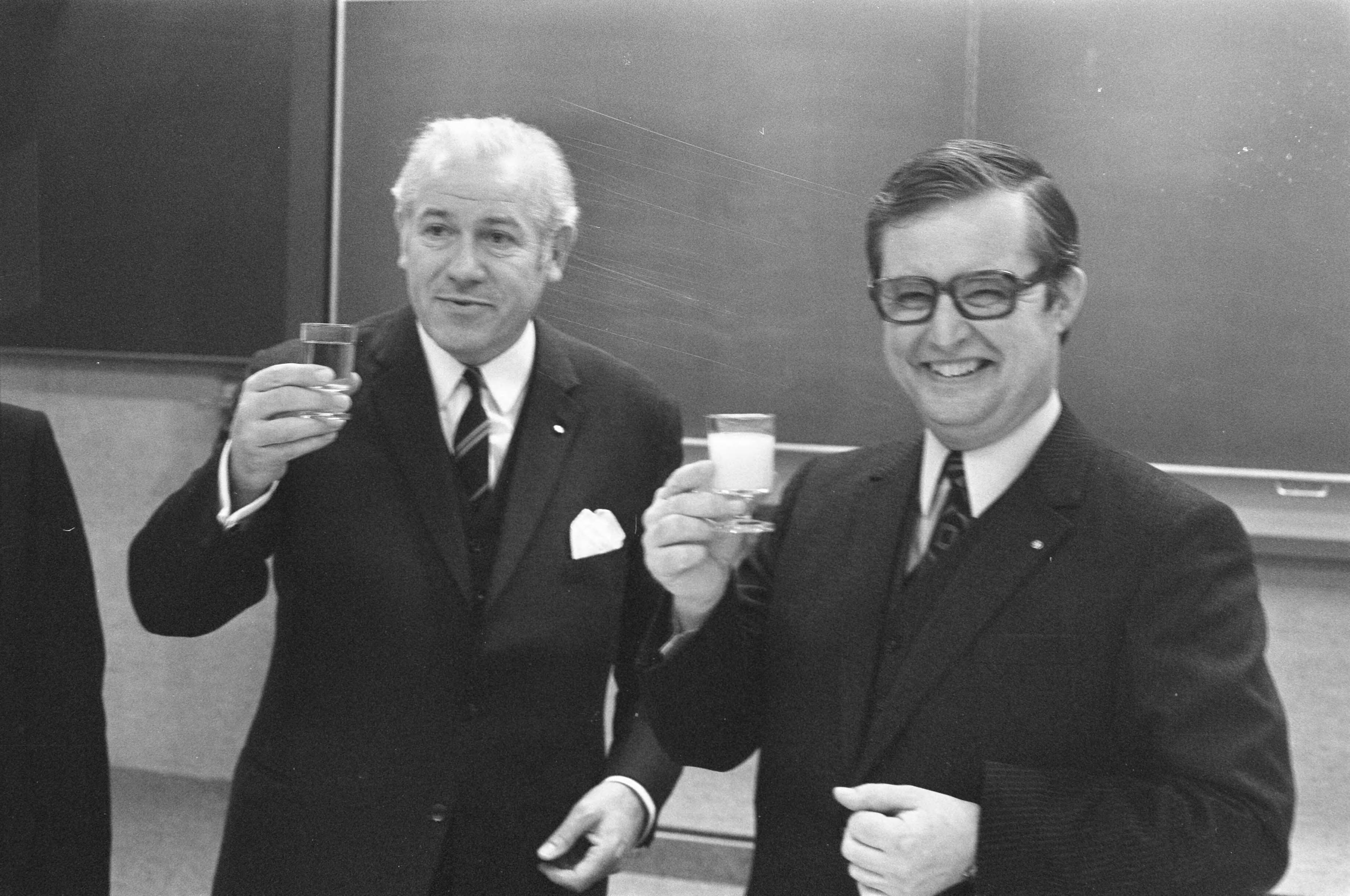 Fotocollectie Anefo — Persconferentie over fusie Albert Heijn en Simon de Wit in Zaandam; D.L. de Bruyn (links) en A. Heijn toosten — Foto: Verhoeff, Bert / Anefo. Licentie: Set B: Rechtenvrij / Publiek Domein. Bron: Nationaal Archief. http://hdl.handle.net/10648/abe1d634-d0b4-102d-bcf8-003048976d84