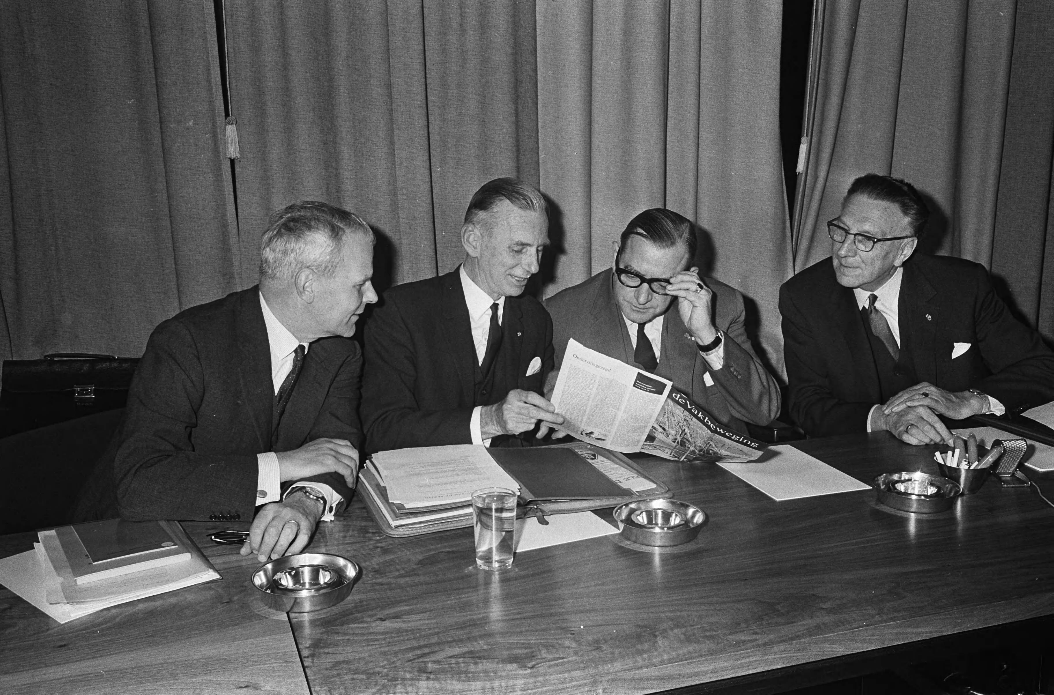 Loonoverleg te Voorburg — Vertegenwoordigers van de werkgevers, vlnr. De Koster, ir J. Bosma, Van Boven, Wemmers. Zij bekijken het tijdschrift "De Vakbeweging" — Foto: Fotograaf Onbekend / Anefo. Licentie: Set B: Rechtenvrij / Publiek Domein. Bron: Nationaal Archief. http://hdl.handle.net/10648/aacfc4cc-d0b4-102d-bcf8-003048976d84