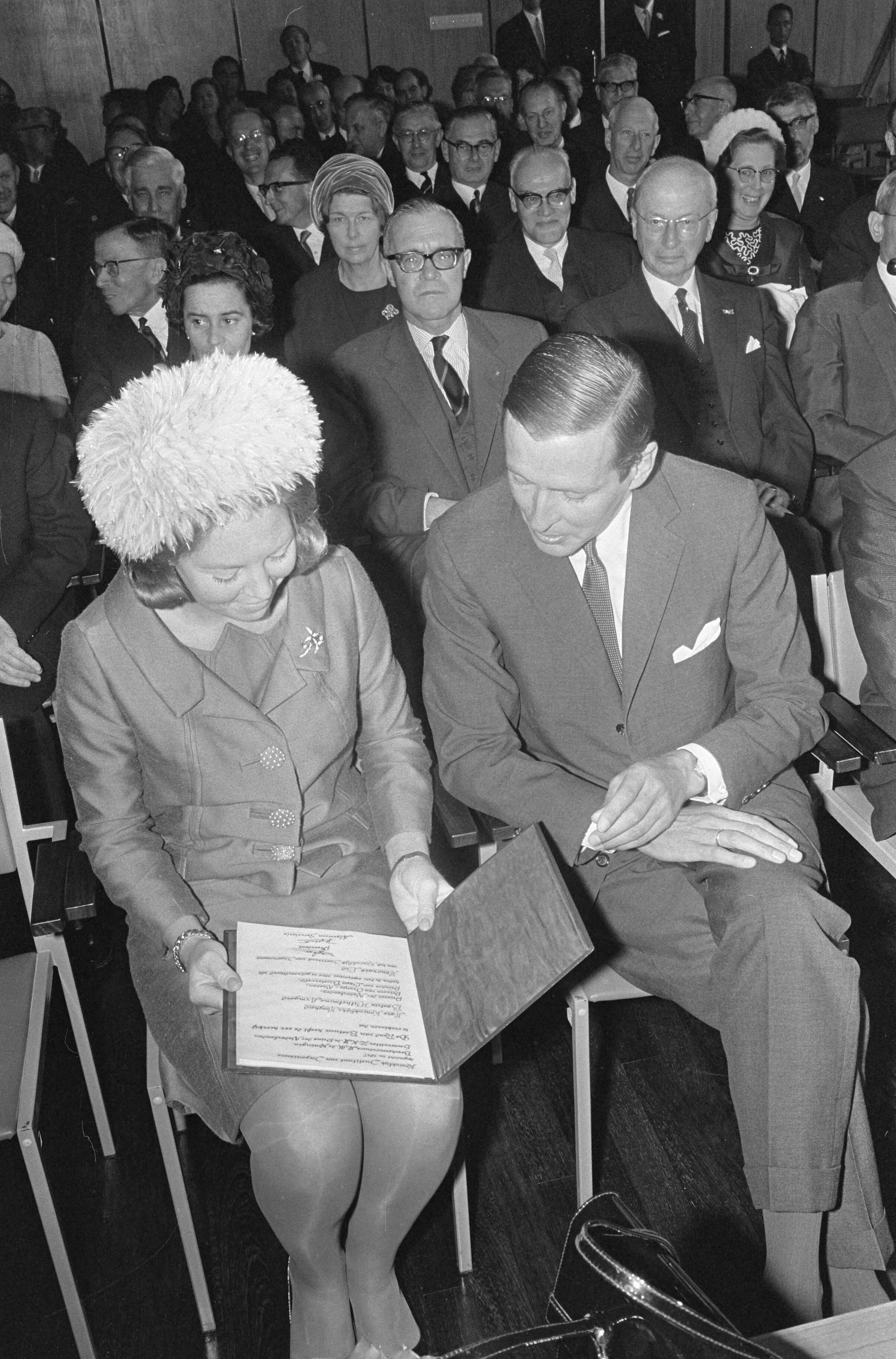Prinses Beatrix lid van het Koninklijk instituut van Ingenieurs te Den Haag — Prinses Beatrix en prins Claus bekijken de zojuist door de prinses ontvangen oorkonde — Foto: Fotograaf Onbekend / Anefo. Licentie: Set B: Rechtenvrij / Publiek Domein. Bron: Nationaal Archief. http://hdl.handle.net/10648/aafbde86-d0b4-102d-bcf8-003048976d84